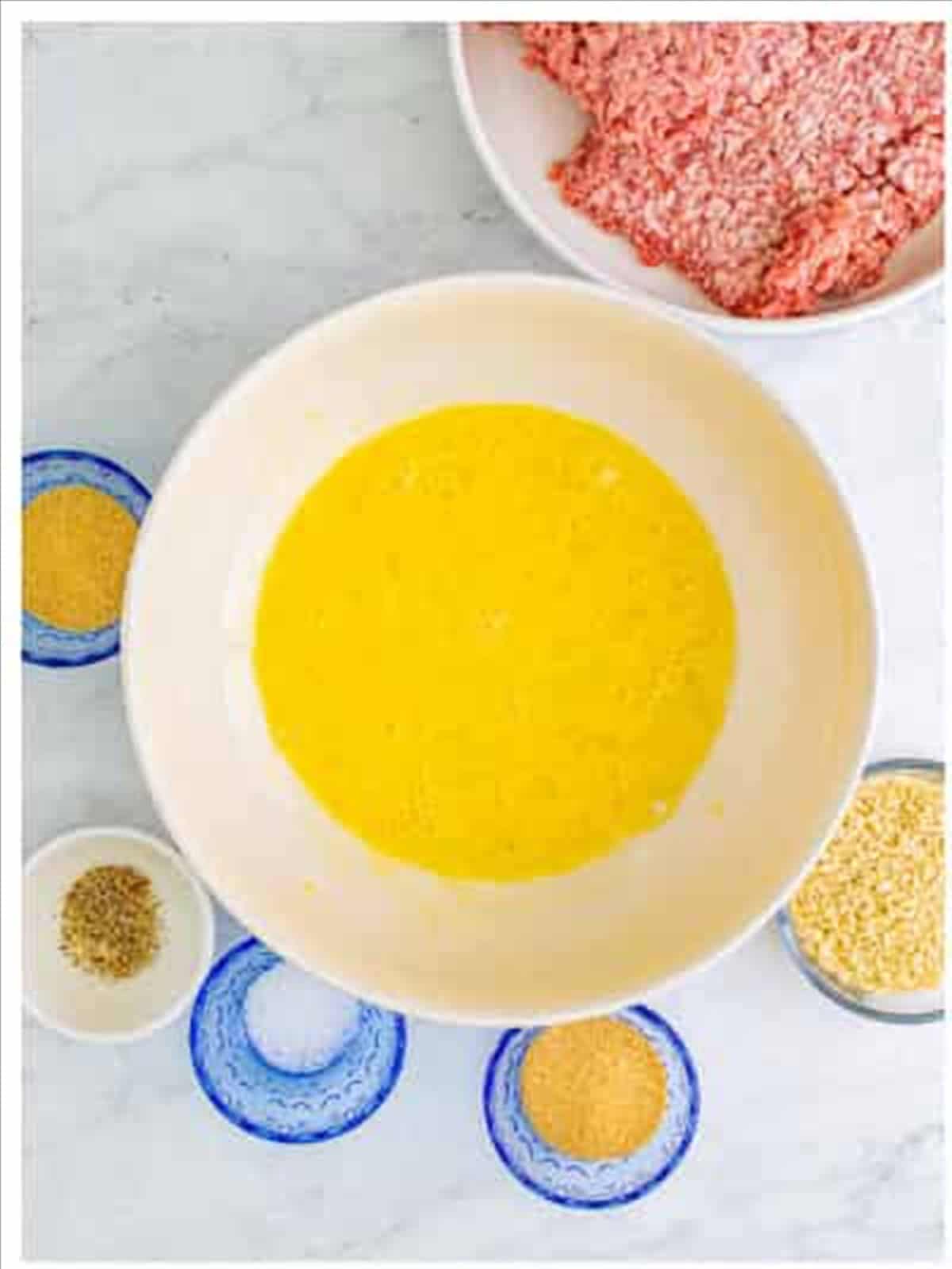 Beaten eggs and seasonings in a bowl for grape jelly meatballs.