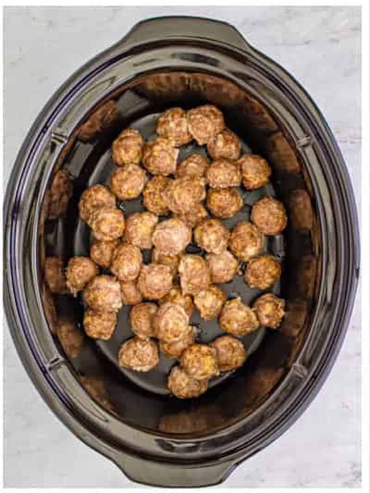 Baked meatballs added to the slow cooker for grape jelly meatballs.