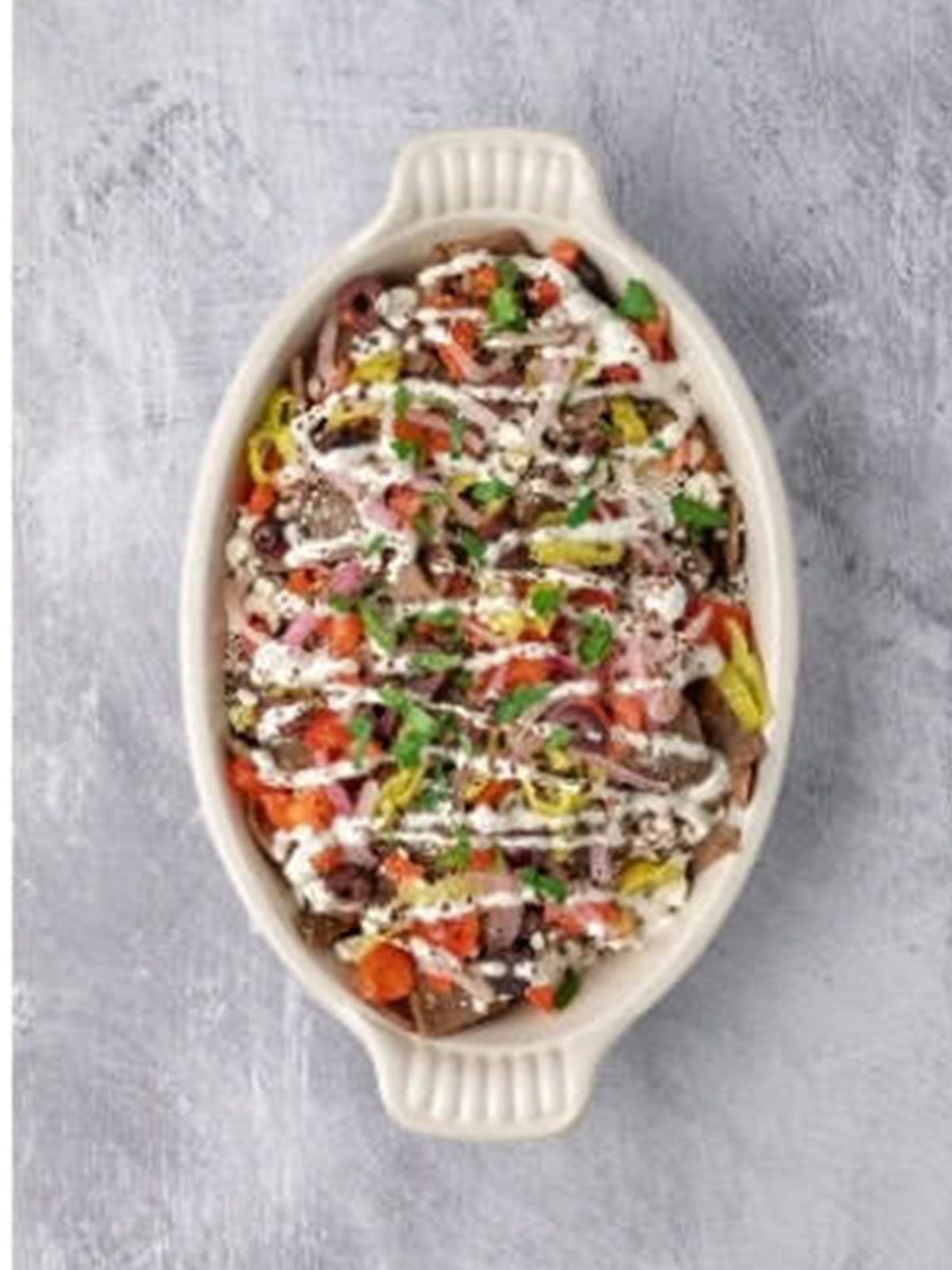 Greek fries drizzled with creamy dill sauce and fresh herbs.