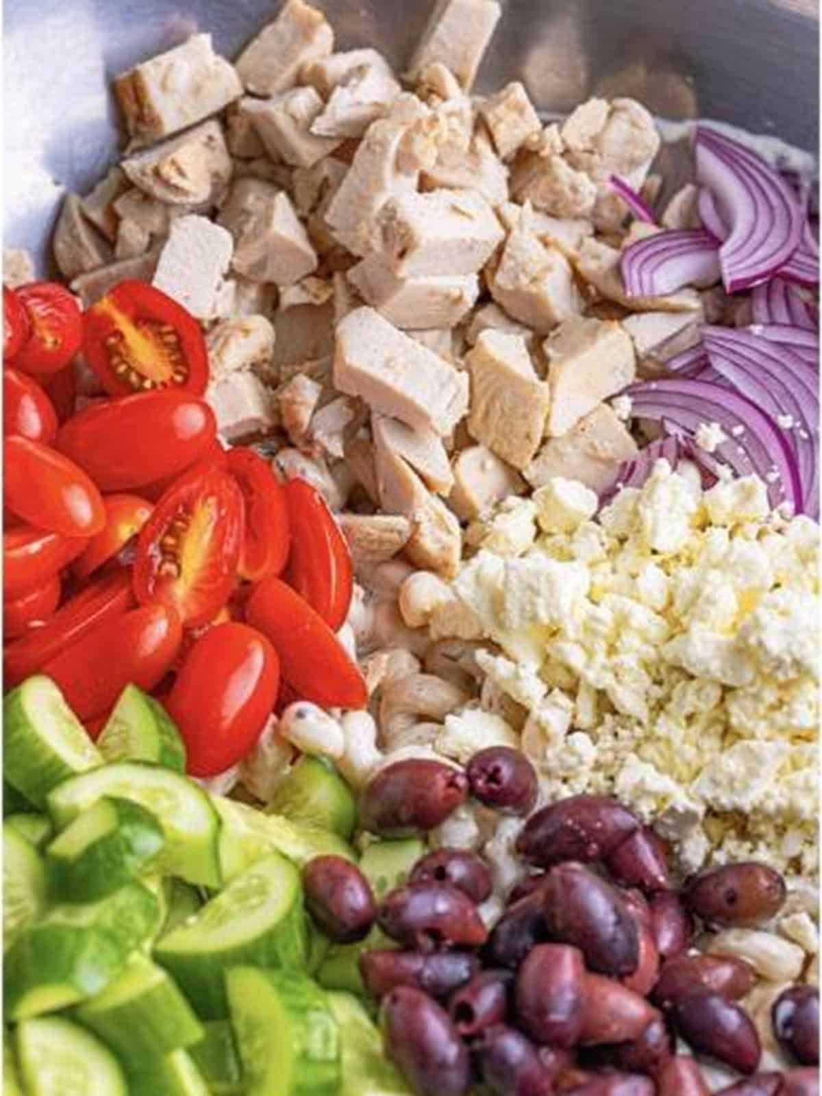 Chicken, tomatoes, feta, cucumbers, olives, and red onion added to Greek Pasta Salad.