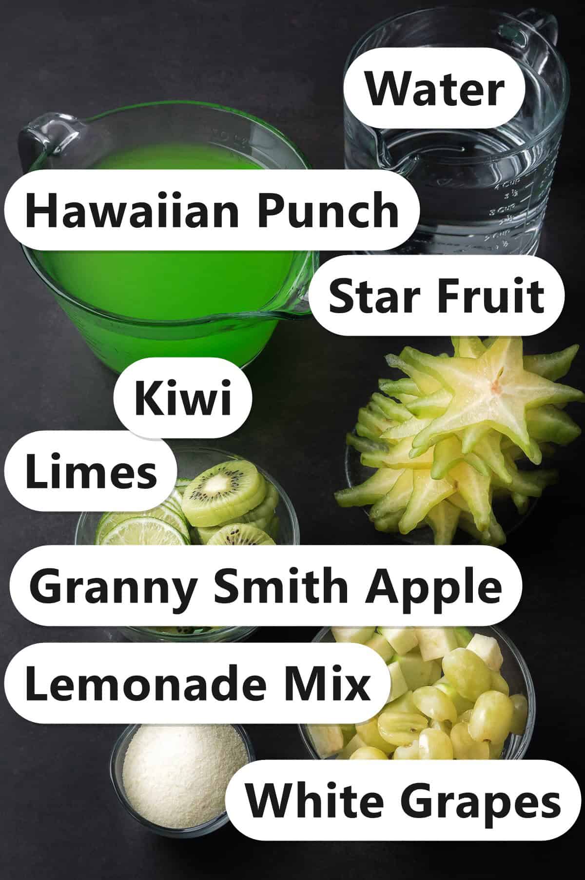 Labeled ingredients for green punch including Hawaiian punch, water, lemonade mix, limes, kiwi, star fruit, Granny Smith apple, and white grapes.