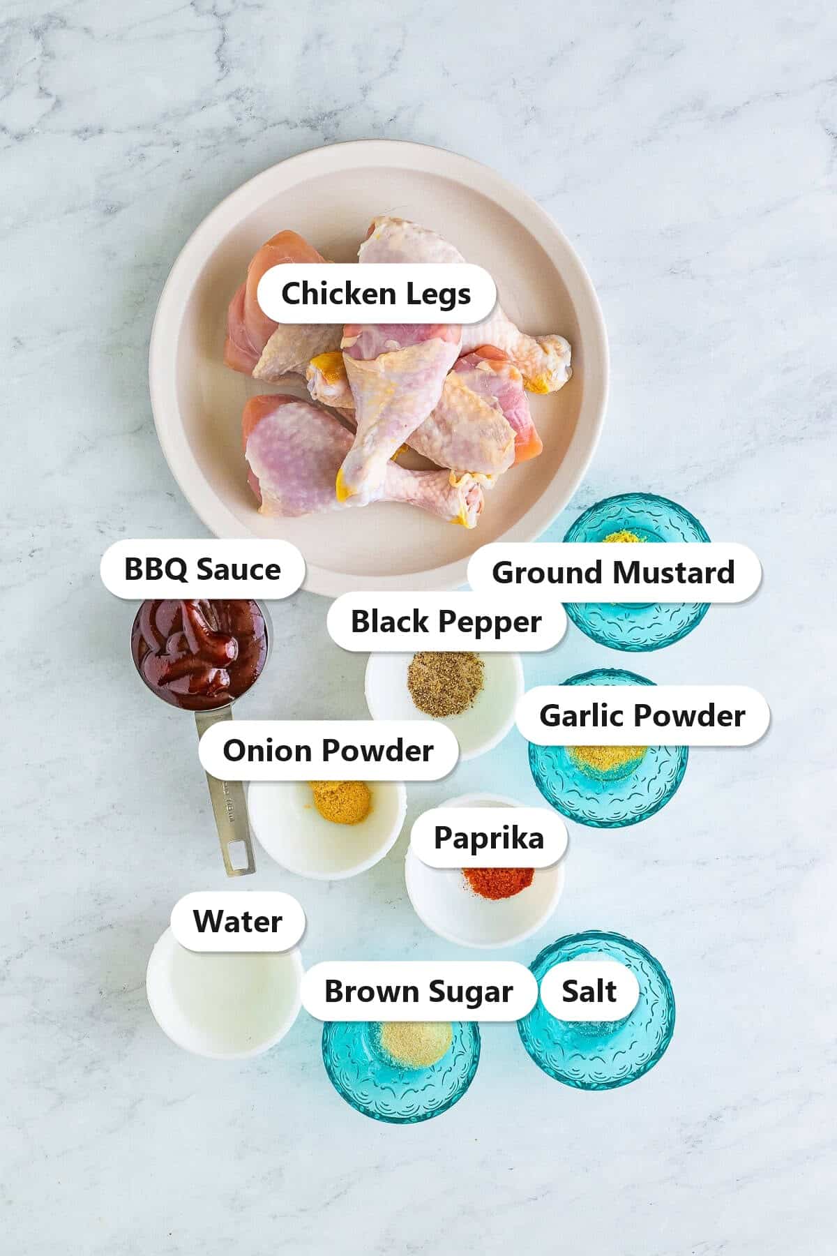 Labeled ingredients for grilled BBQ chicken legs including chicken legs, BBQ sauce, brown sugar, garlic powder, onion powder, paprika, ground mustard, salt, and pepper.