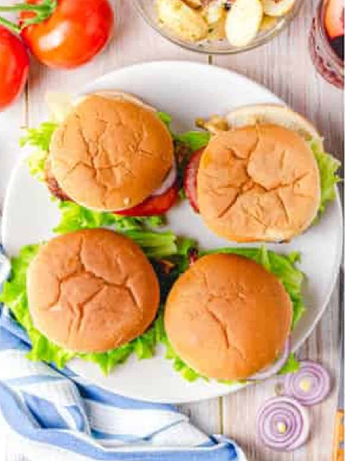 Finished Grilled Chicken Sandwiches stacked on a plate ready to serve.