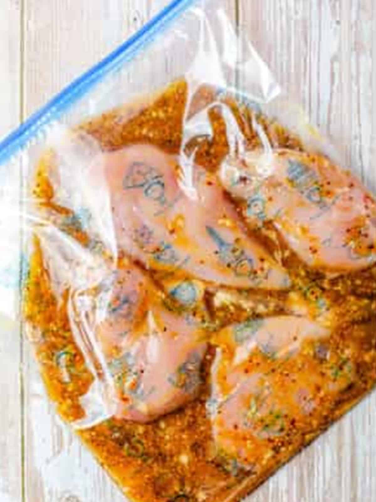Chicken breasts marinating in a zip top bag for Grilled Chicken Sandwiches.