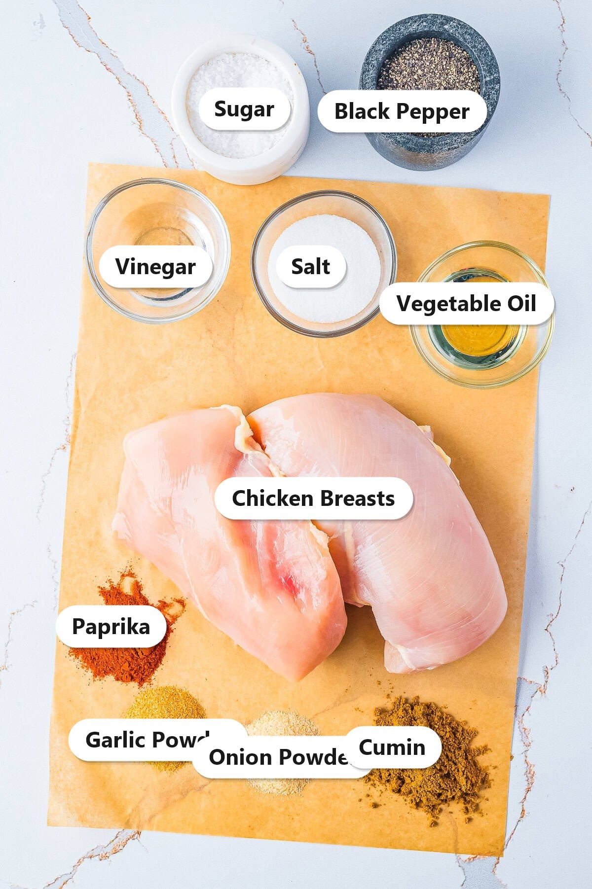 Labeled ingredients for grilled chicken tacos including chicken breasts, sugar, vinegar, oil, cumin, paprika, garlic powder, onion powder, salt, and pepper.