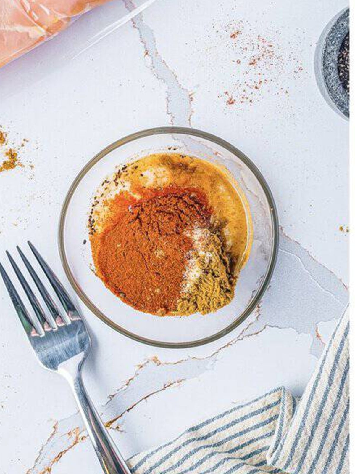 Cumin, paprika, sugar, and spices combined in a small bowl for chicken taco marinade.