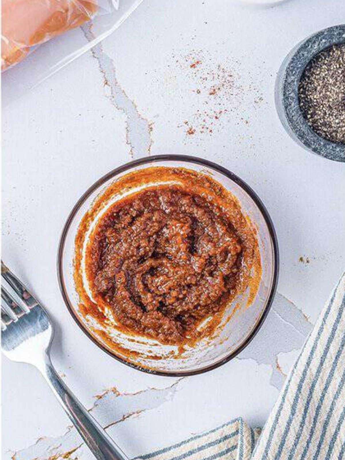 Chicken taco marinade whisked together in a small glass bowl.