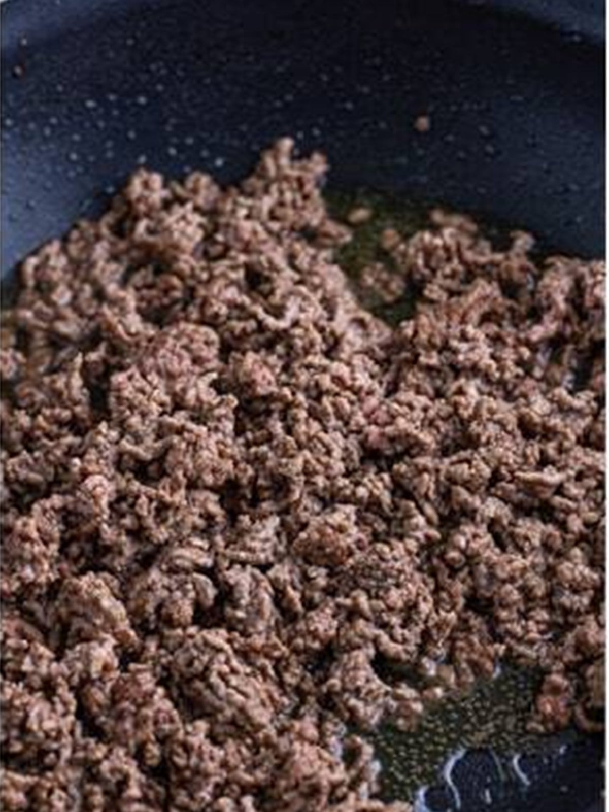 Ground beef browning in a skillet for ground beef stroganoff.