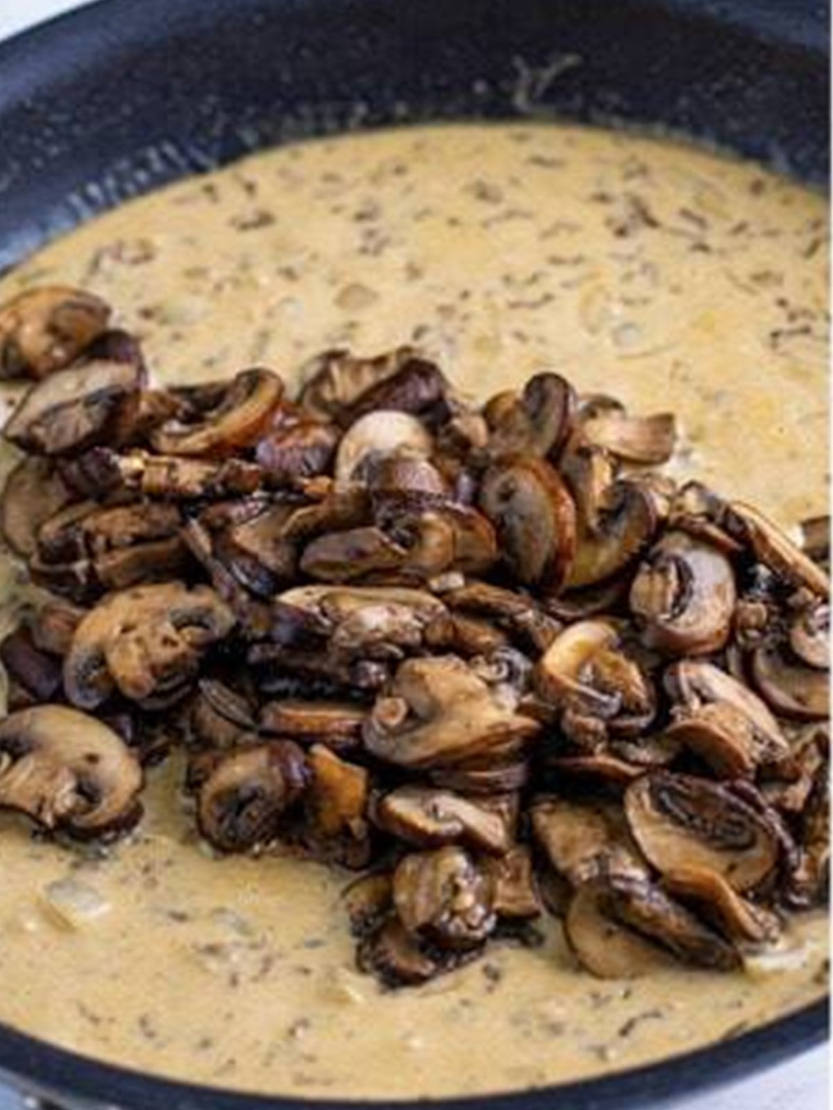 Seared mushrooms added back into the creamy stroganoff sauce.