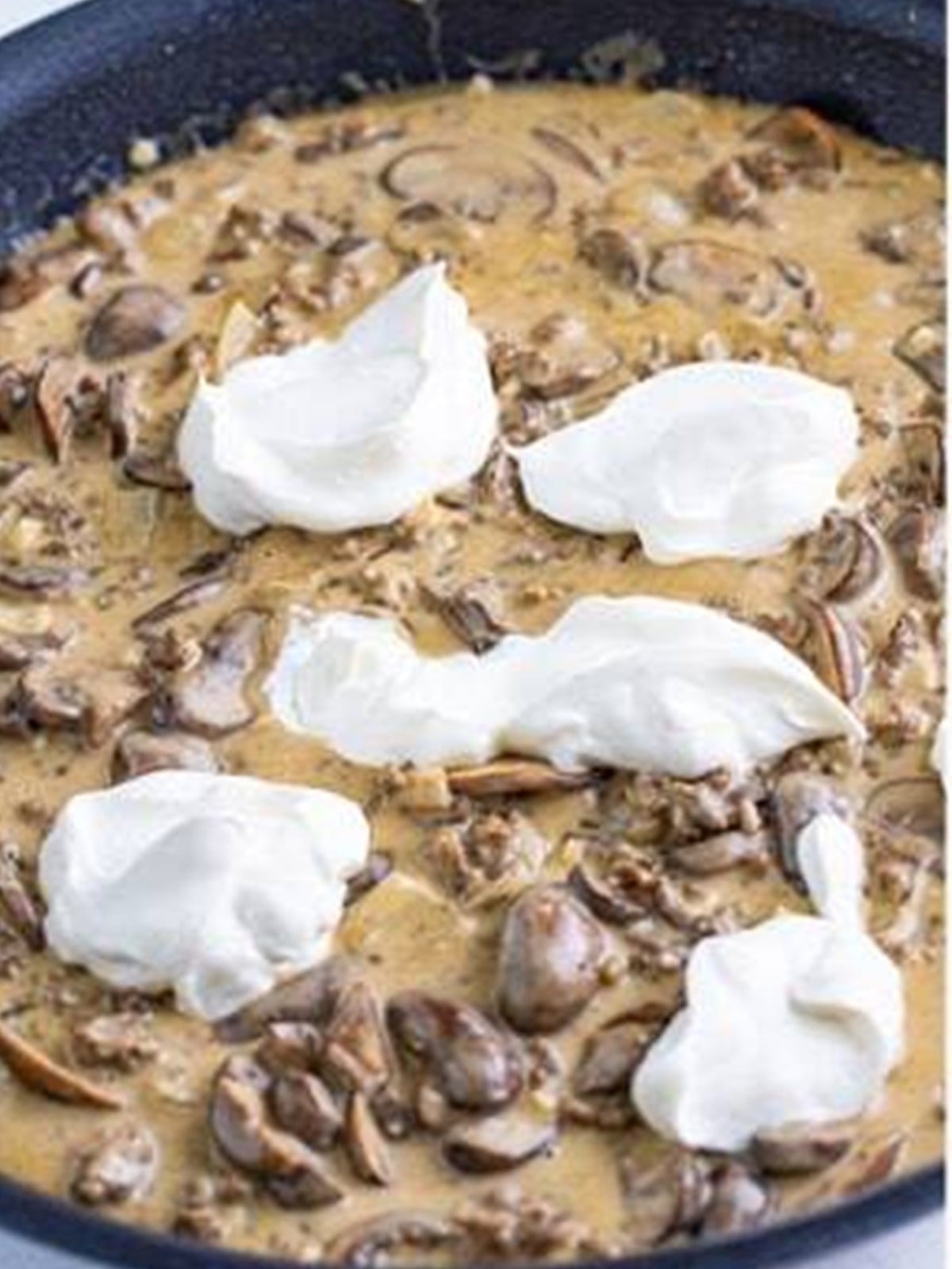 Dollops of sour cream added to the ground beef stroganoff.