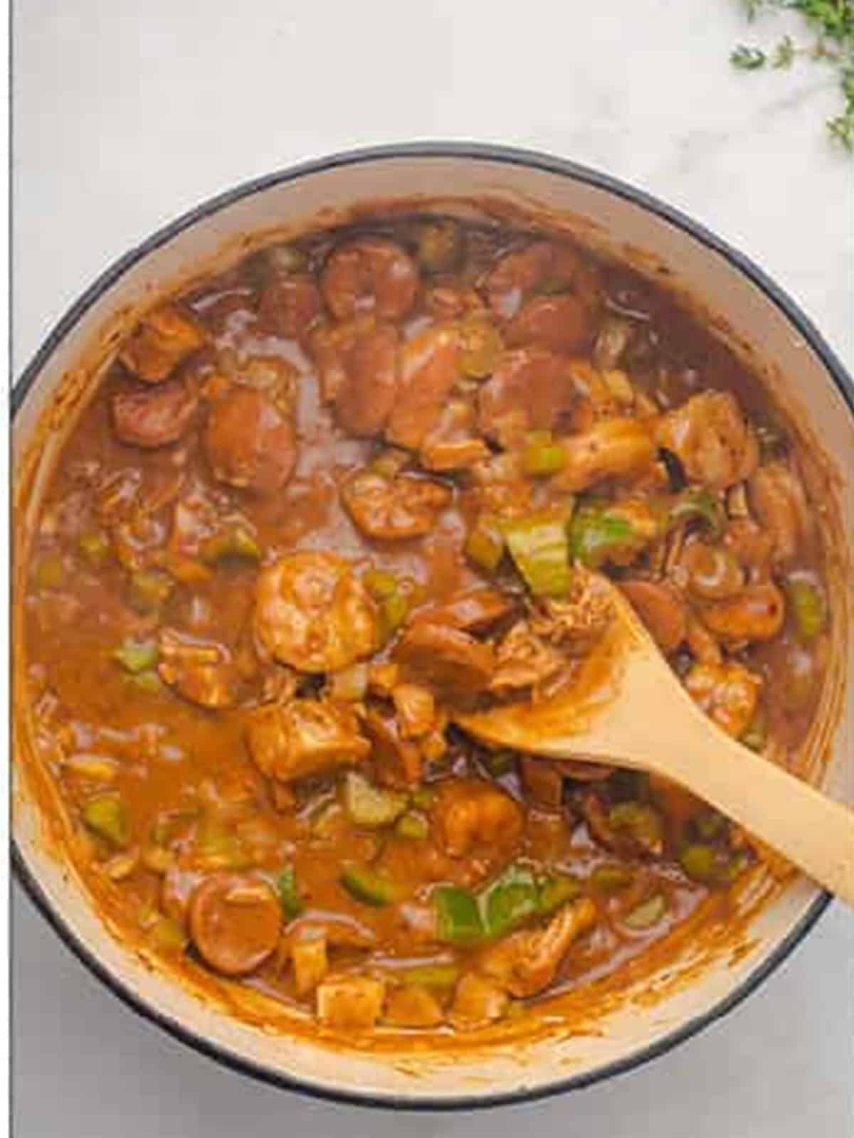 Finished gumbo recipe simmered thick with sausage, chicken, and shrimp in a pot.
