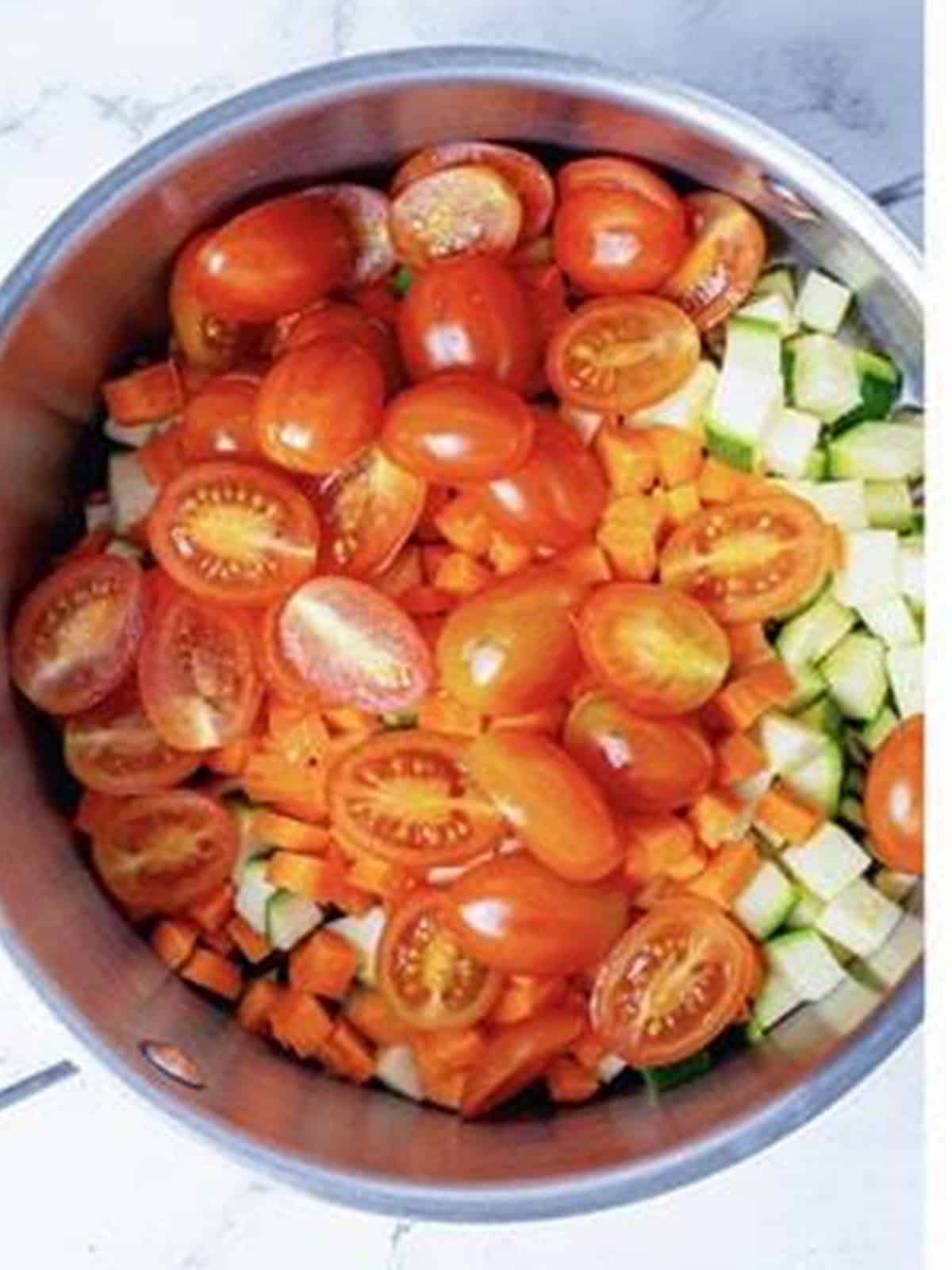 Zucchini, carrot, and grape tomatoes added to a pot to start the veggie marinara.