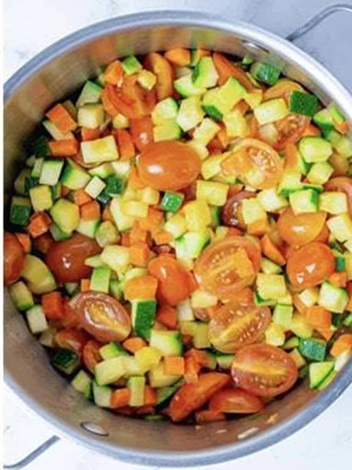 Diced vegetables sauteing in a pot for chunky veggie marinara sauce.