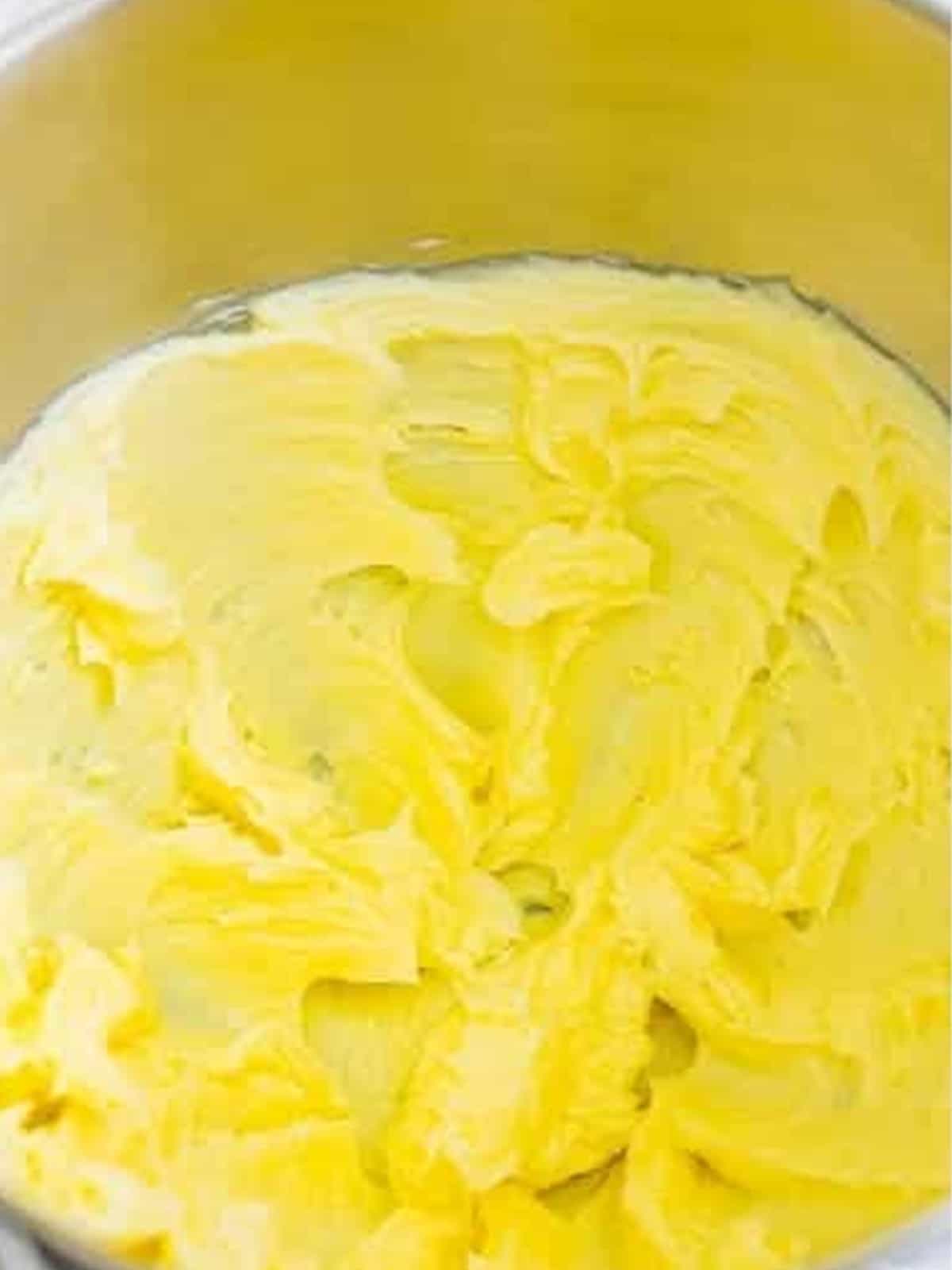 Whipping softened butter in a stand mixer for vanilla buttercream frosting.