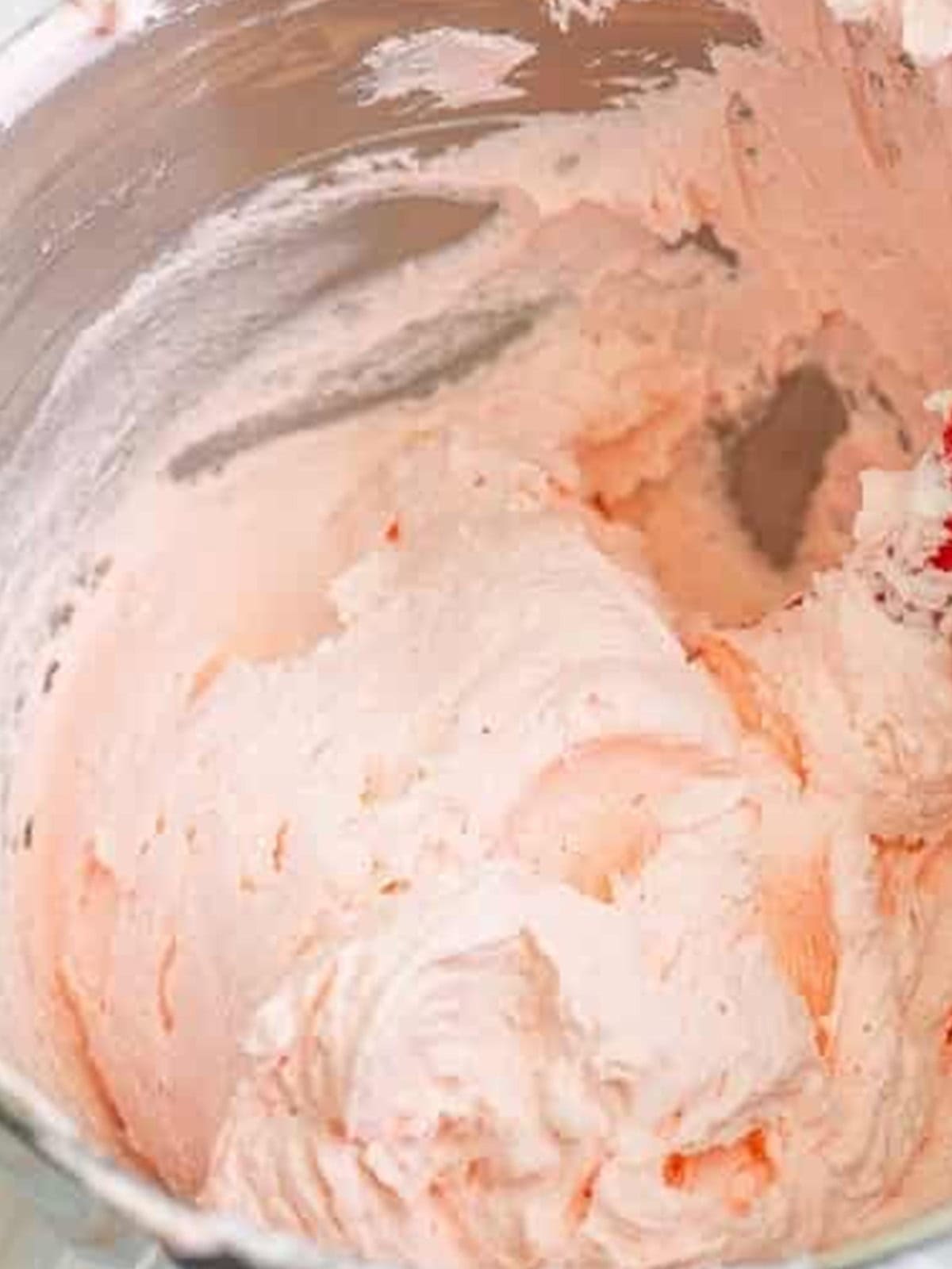 Pink tinted vanilla buttercream frosting ready to pipe onto the birthday cupcakes.