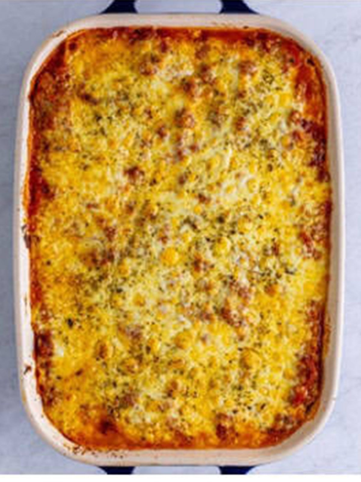 Baked homemade lasagna with golden bubbly melted cheese on top.