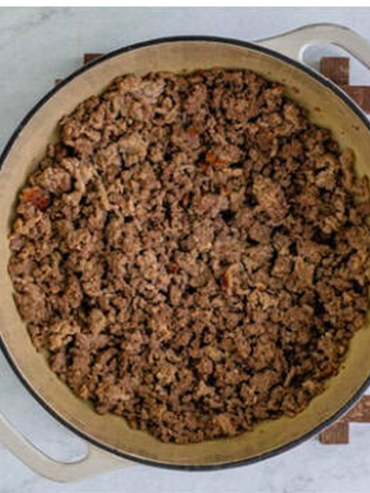 Ground beef and Italian sausage browned in a pot for homemade lasagna meat sauce.