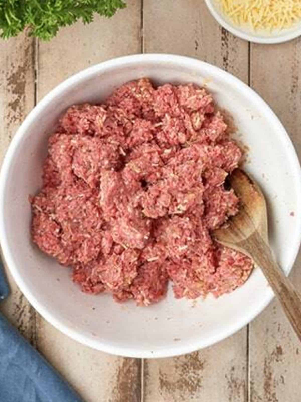 Ground beef folded into the seasoned breadcrumb mixture for homemade meatballs.