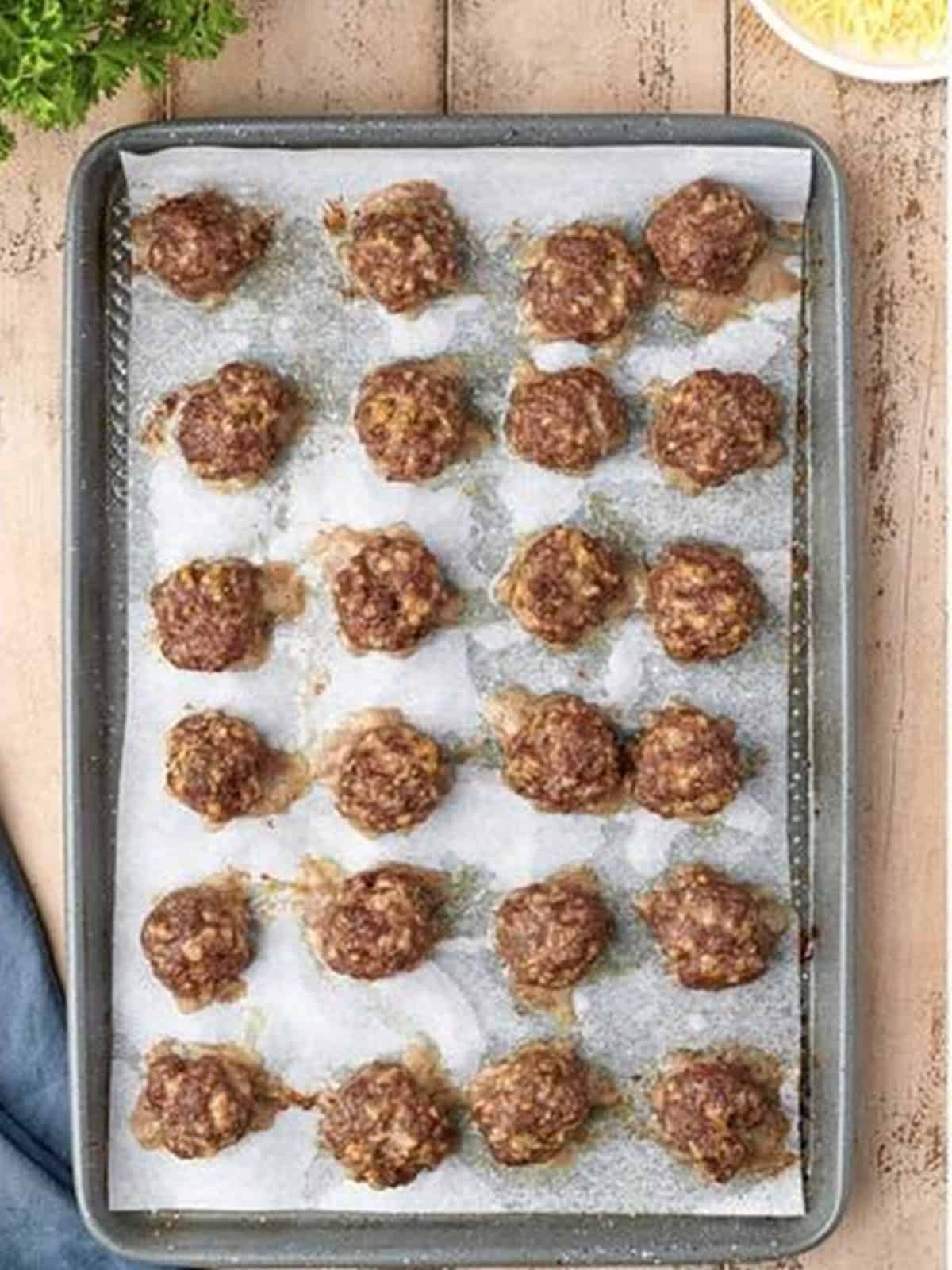 Golden baked homemade meatballs on a sheet pan fresh from the oven.