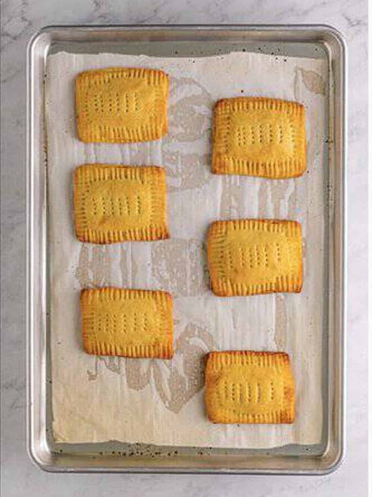 Baked homemade pop tarts on a sheet pan.