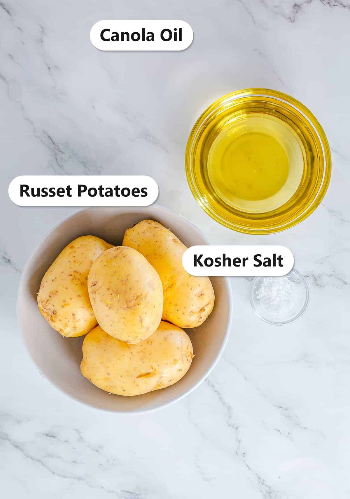Homemade Potato Chips ingredients including russet potatoes, canola oil, and kosher salt labeled on a marble counter.