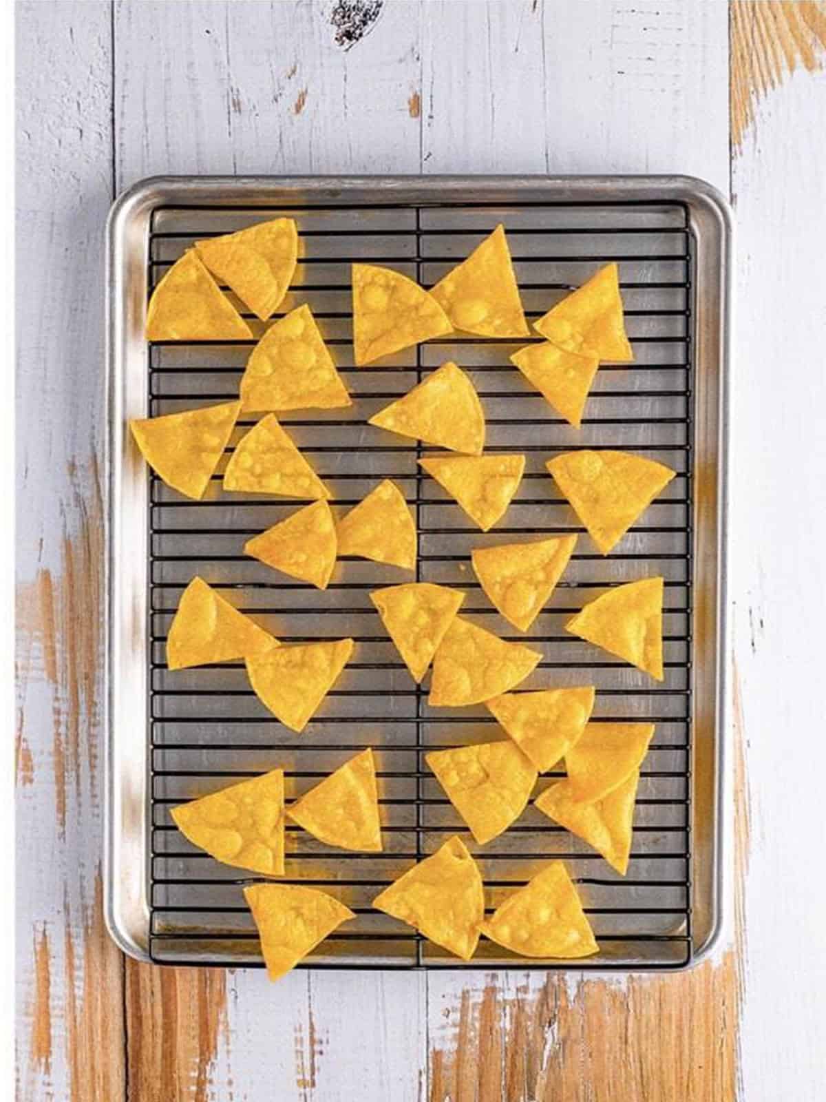 Crispy homemade tortilla chips cooling on a wire rack.