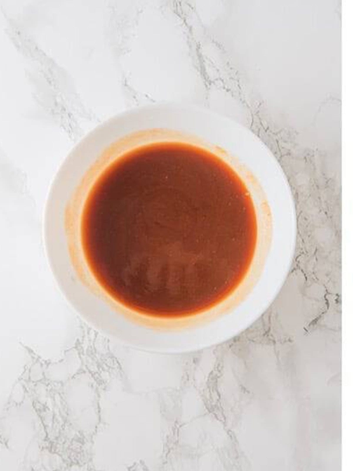 Honey BBQ Sriracha sauce mixed together in a white bowl.