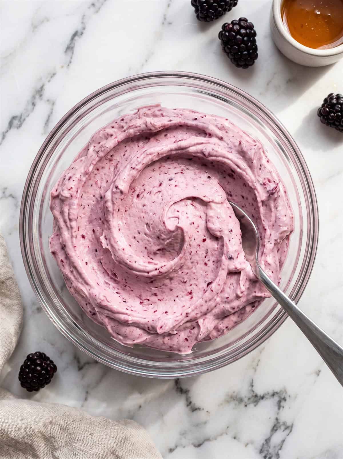 Finished fluffy whipped blackberry honey butter in a glass bowl ready to serve.