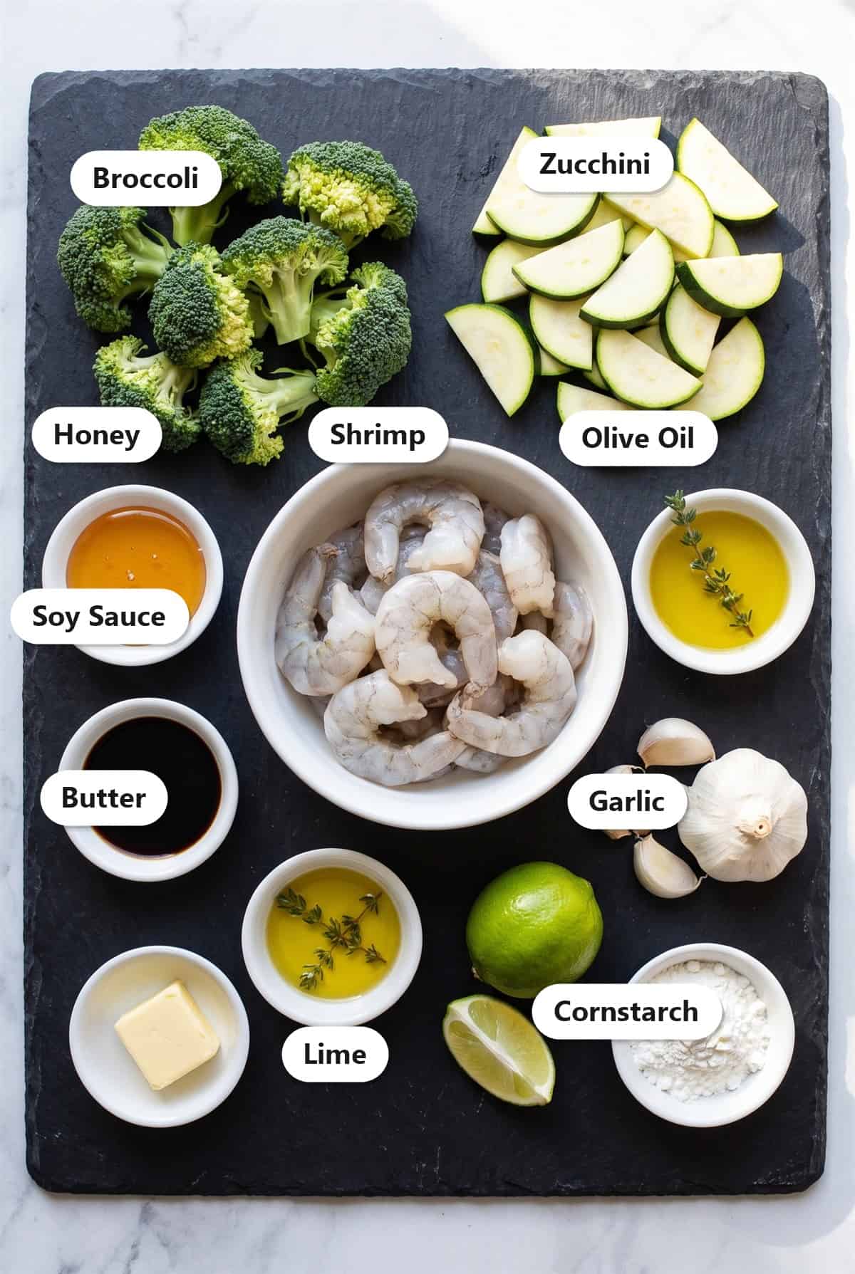 Labeled ingredients for honey garlic shrimp stir fry including shrimp, broccoli, zucchini, honey, soy sauce, garlic, butter, lime, and cornstarch.