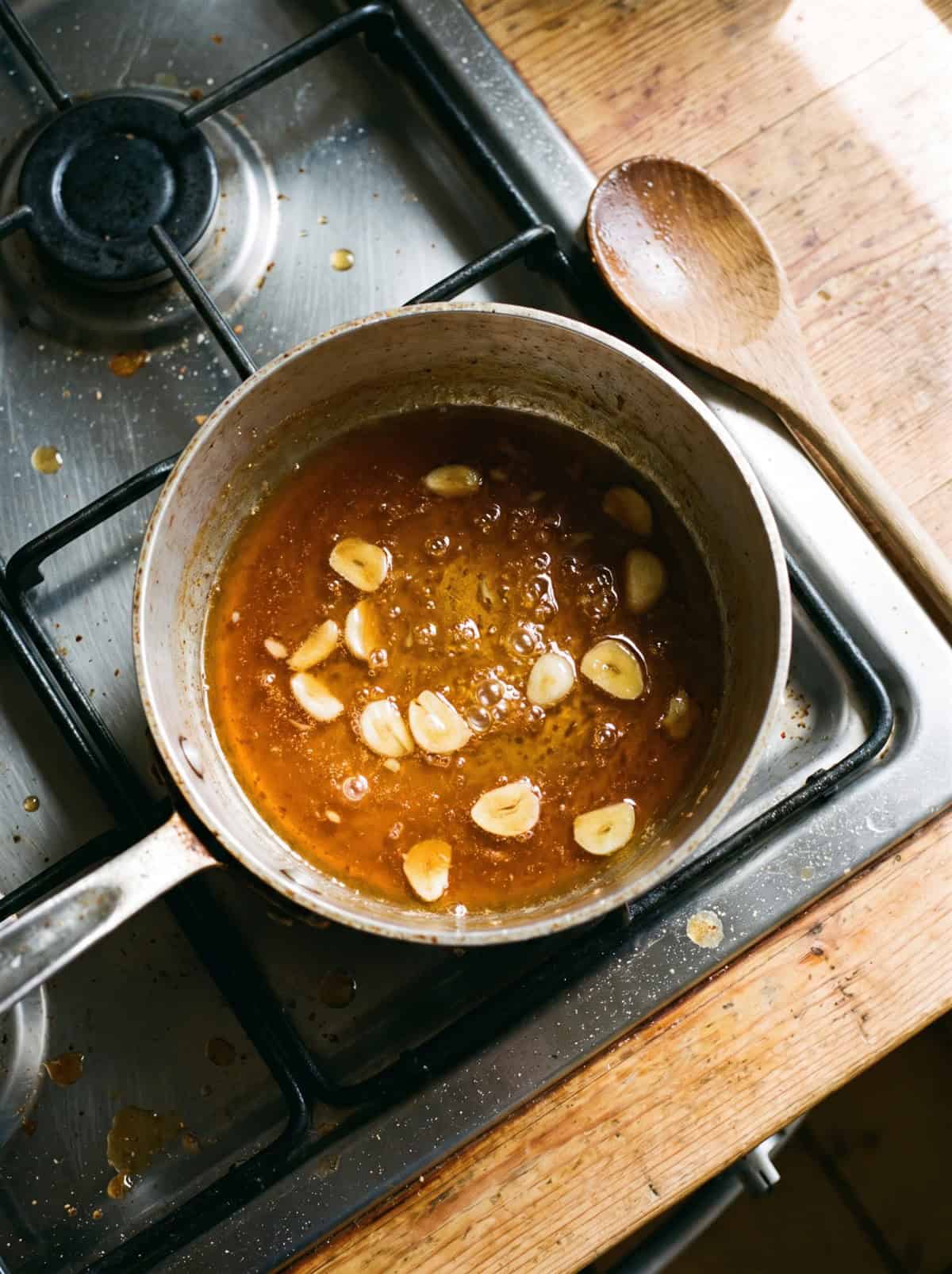 Honey garlic sauce simmering in a small saucepan.