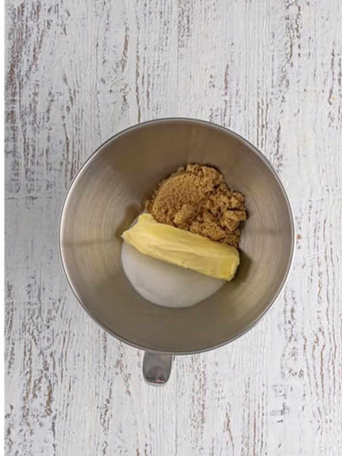 Butter and sugars creamed together in a stand mixer bowl.
