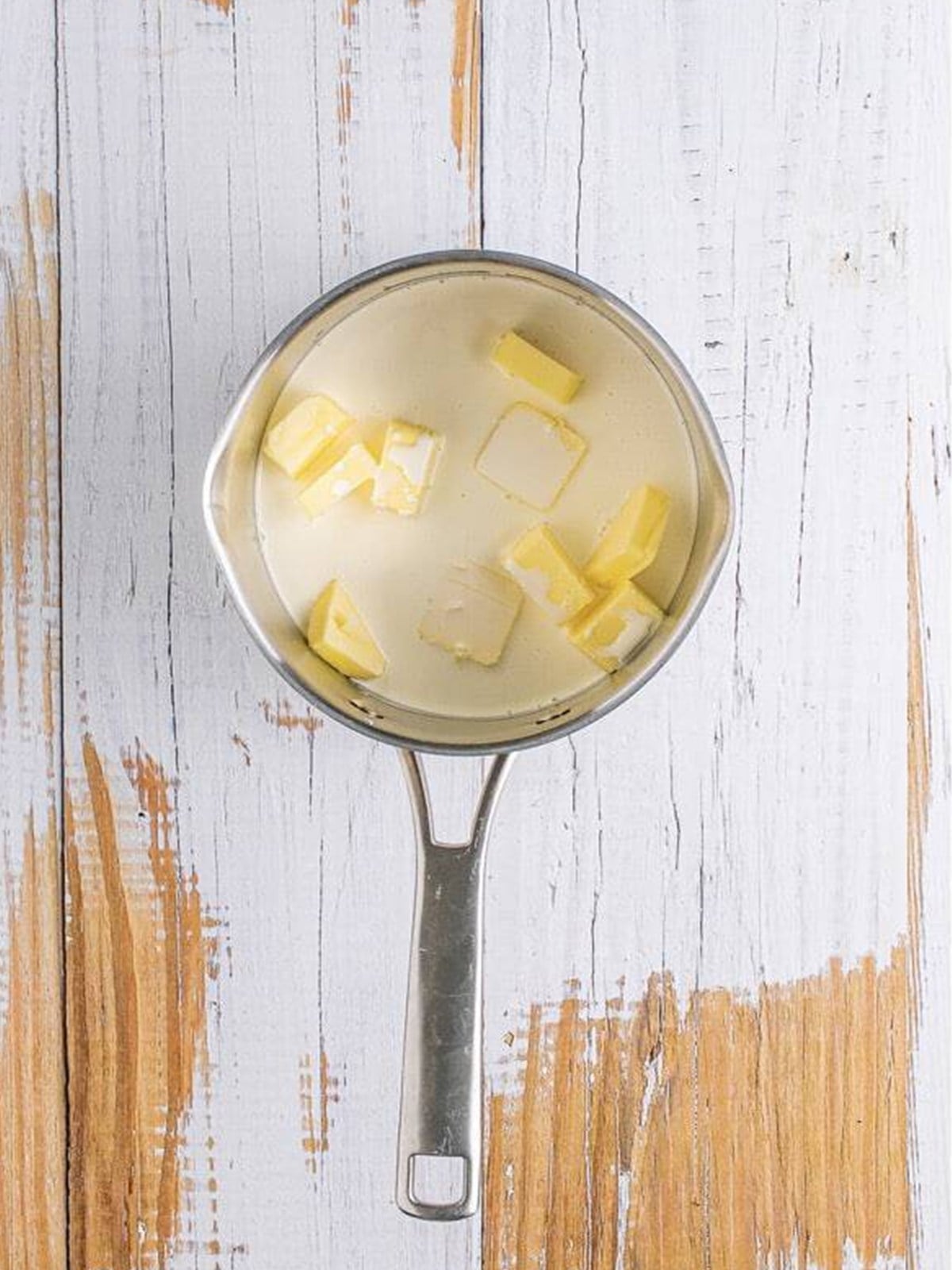 Butter and heavy cream melting in a saucepan for hot fudge sauce.