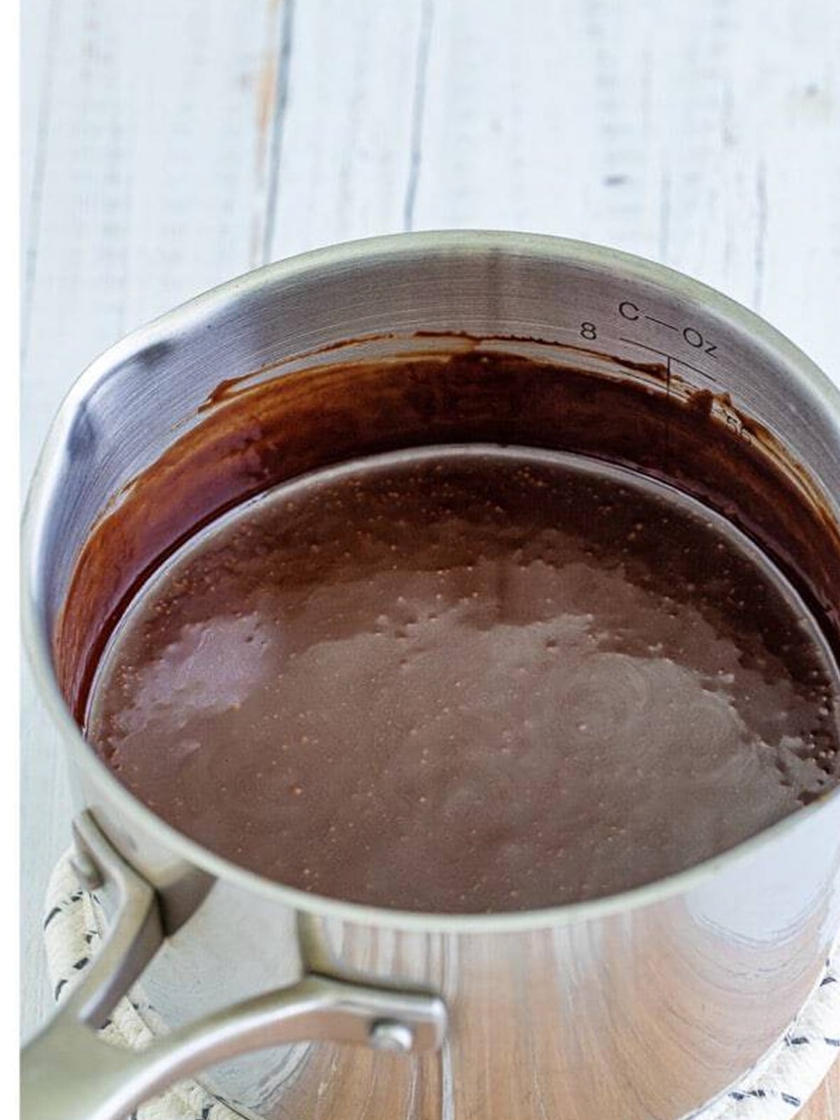 Thickened homemade hot fudge sauce in a saucepan.