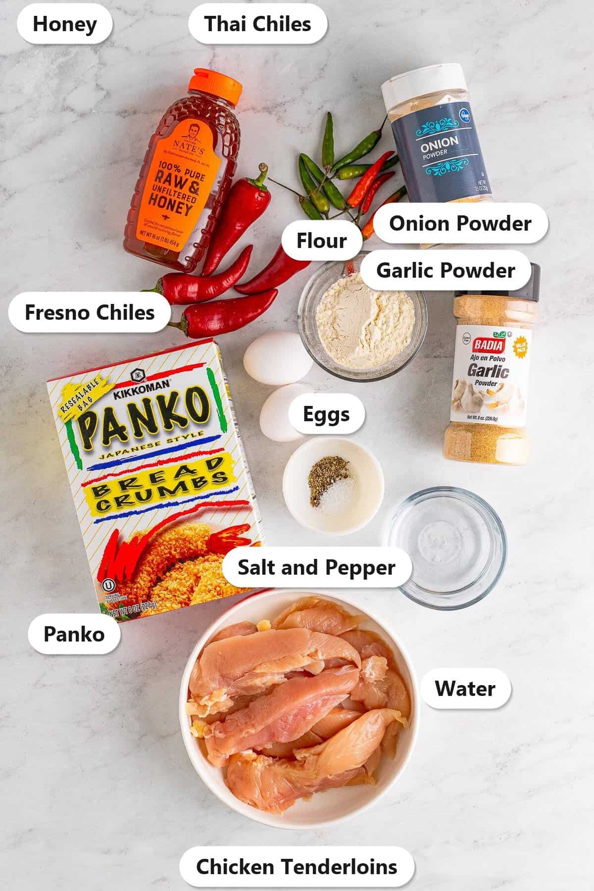 Ingredients to make Hot Honey Chicken laid out and labeled on a marble counter.