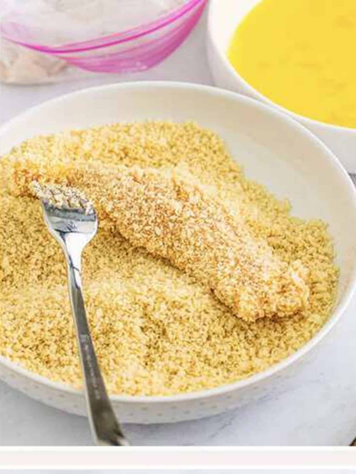 A chicken tender pressed into panko breadcrumbs for Hot Honey Chicken.