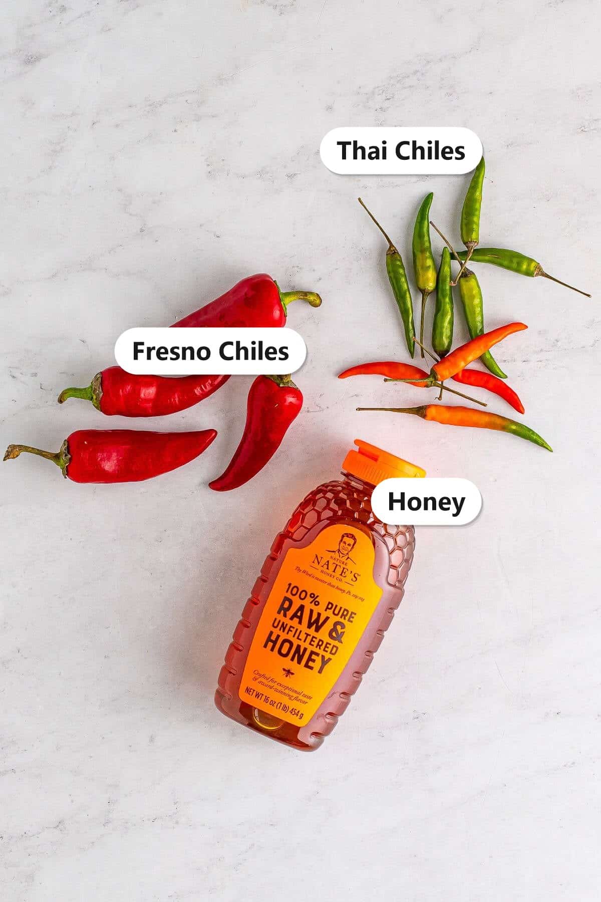 Labeled ingredients for hot honey including Fresno chiles, Thai chiles, and pure honey.