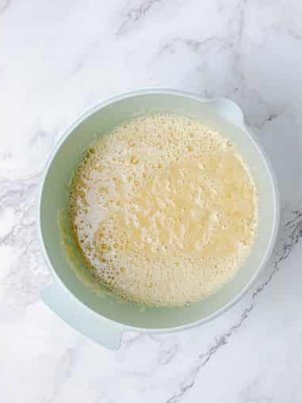 Eggs, mashed banana, pineapple, and applesauce whisked together for hummingbird cake.