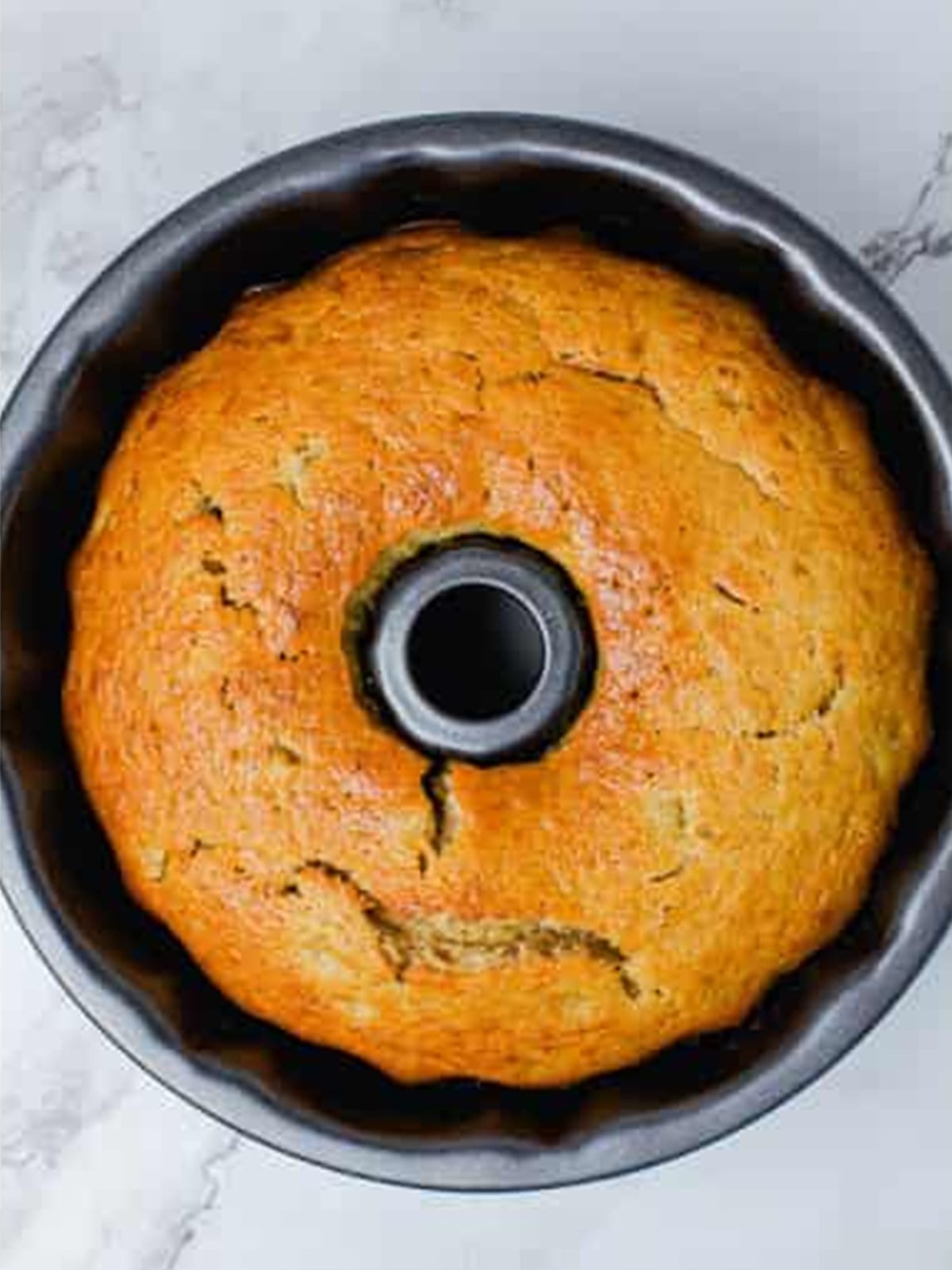 A golden baked hummingbird bundt cake in the pan after baking.