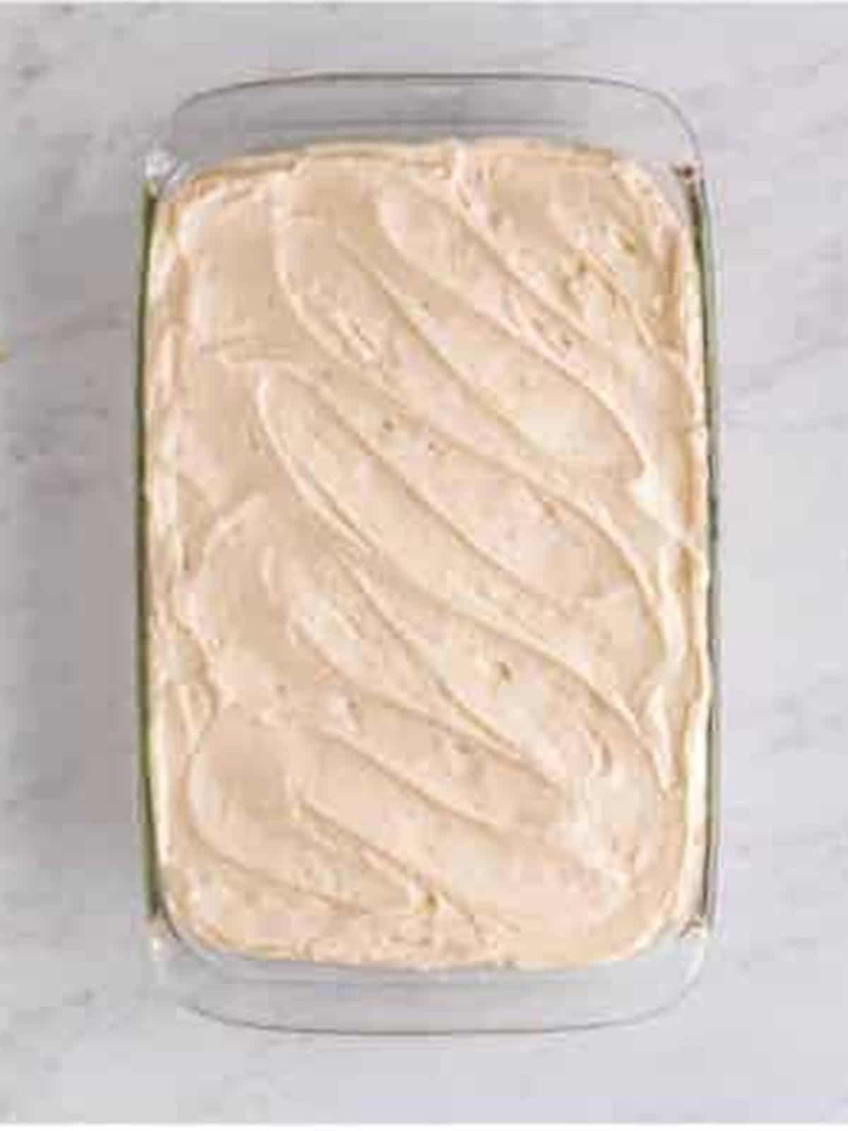 Cream cheese frosting spread over the cooled Hummingbird Cake.