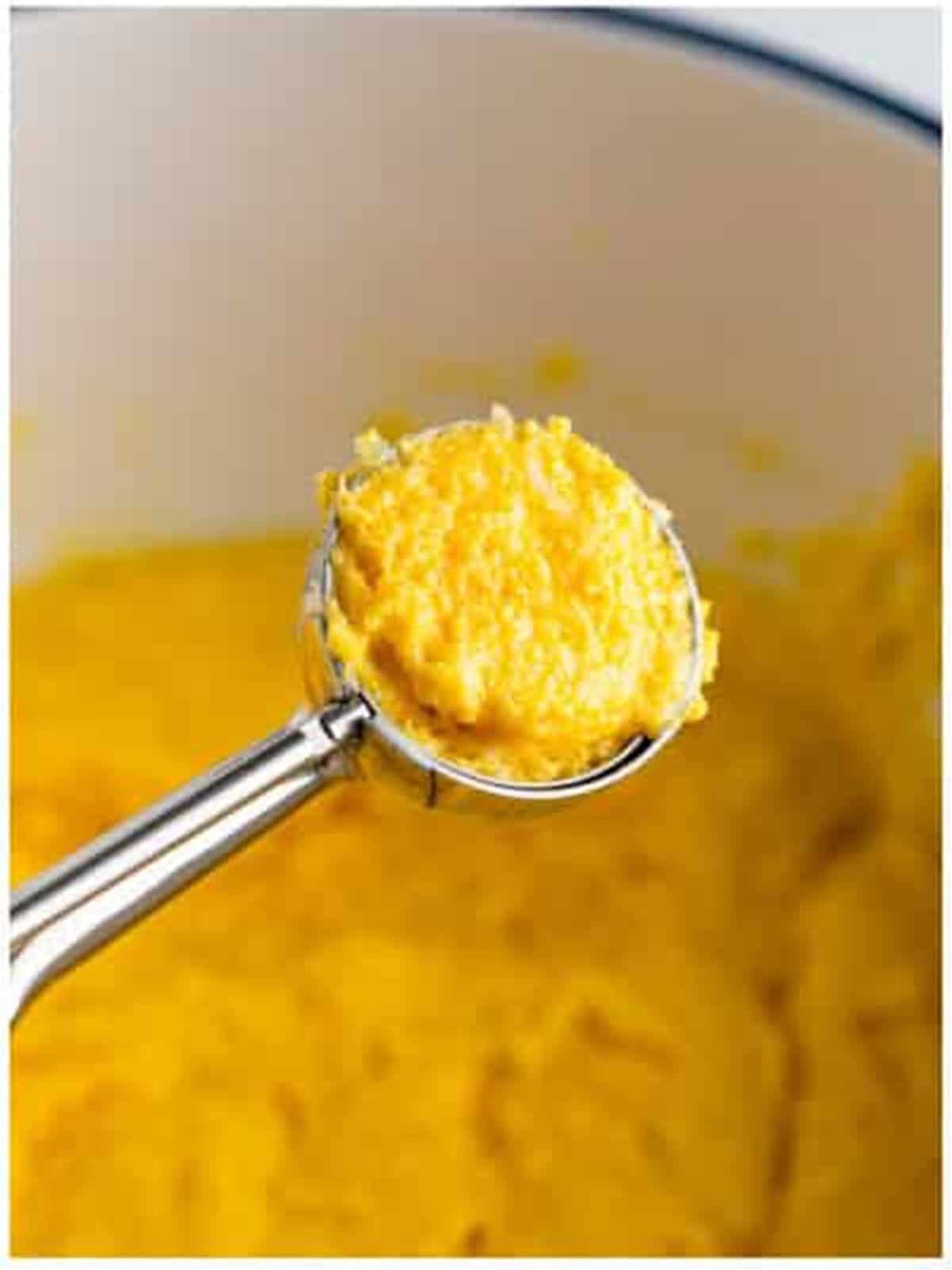 Scooping hush puppy batter into hot oil.