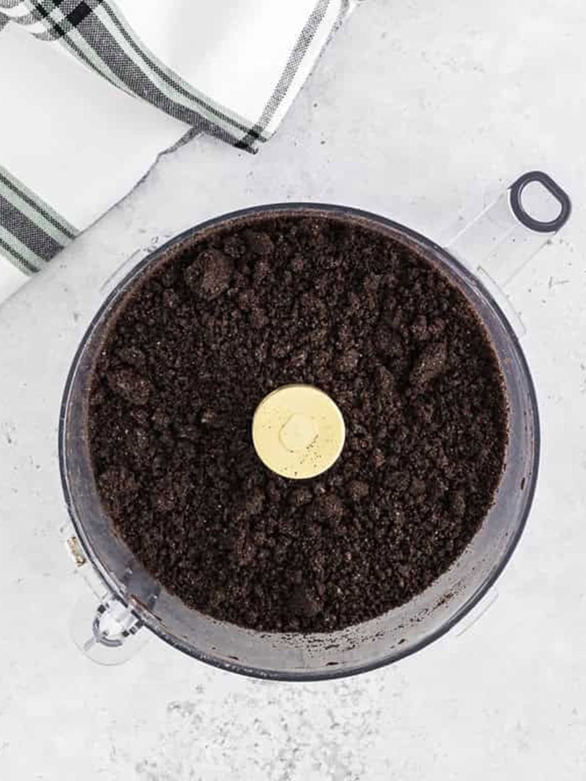 Oreos processed into fine crumbs in a food processor for ice cream dirt cake.