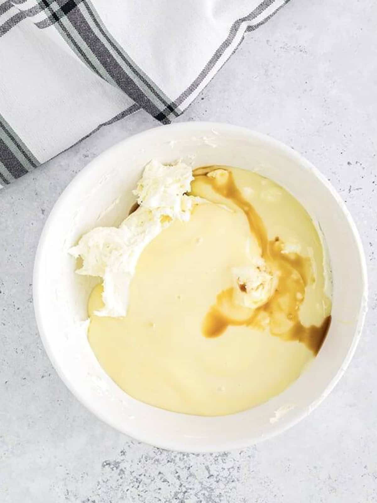 Cream cheese, sweetened condensed milk, and vanilla in a bowl for the dirt cake filling.