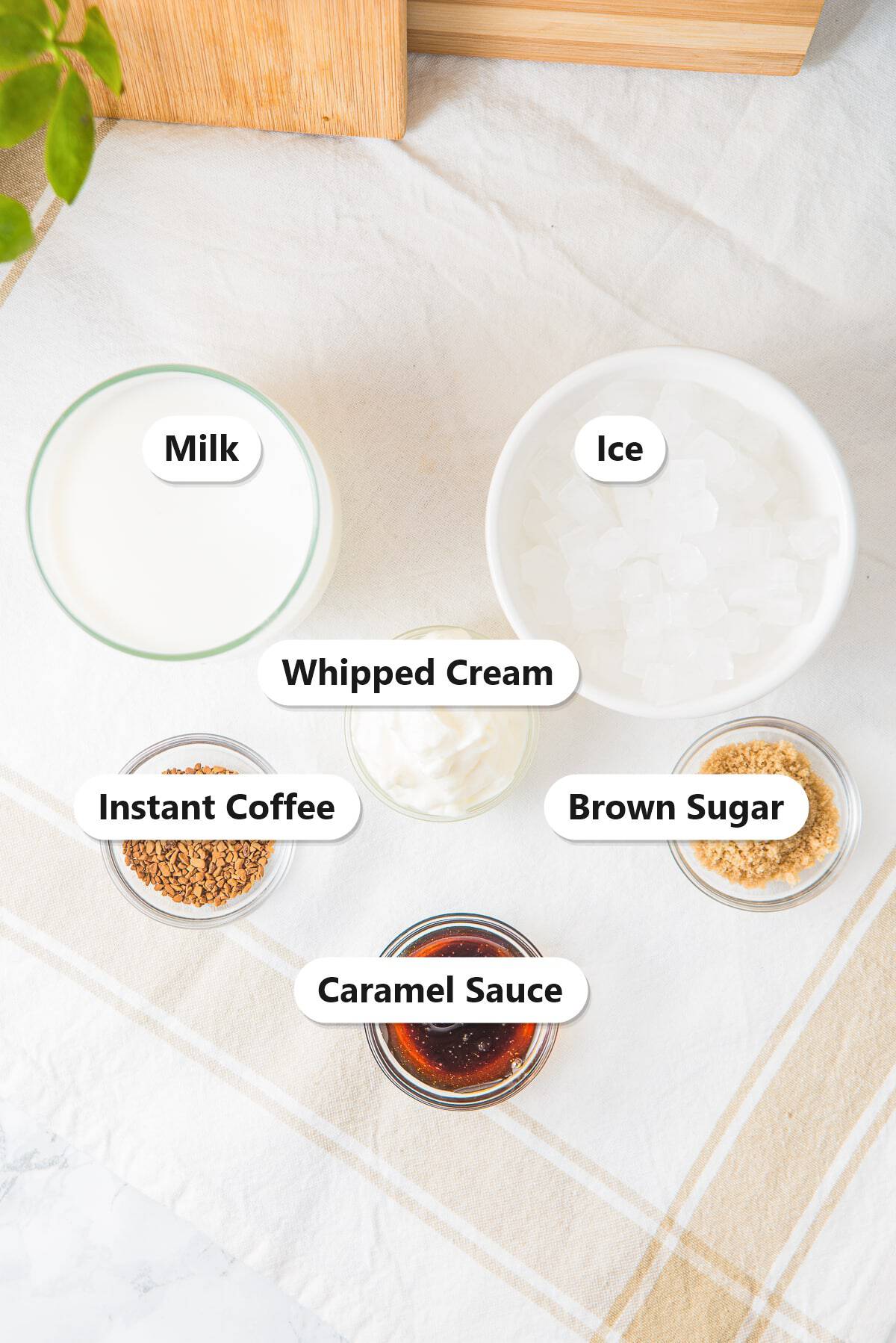 Labeled iced caramel latte ingredients including milk, ice, instant coffee, brown sugar, caramel sauce, and whipped cream.