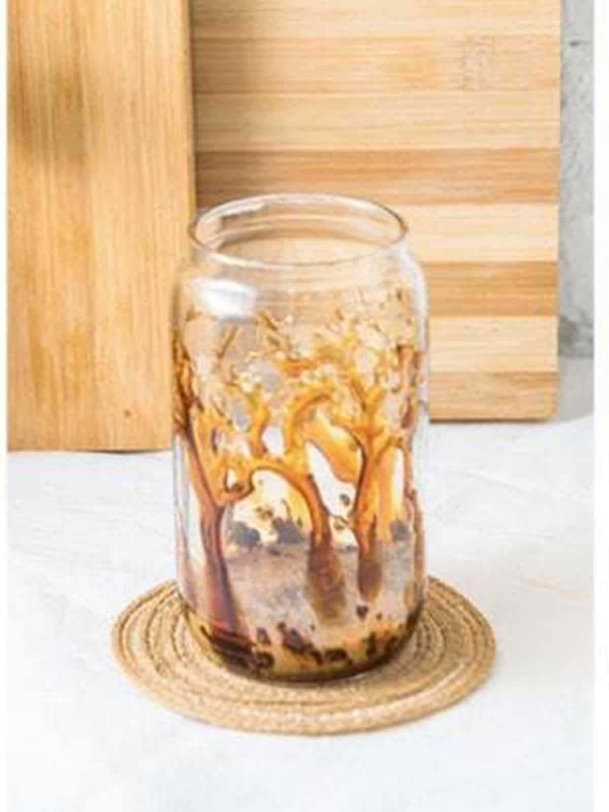 Coffee and caramel in the bottom of a glass for an iced caramel latte.
