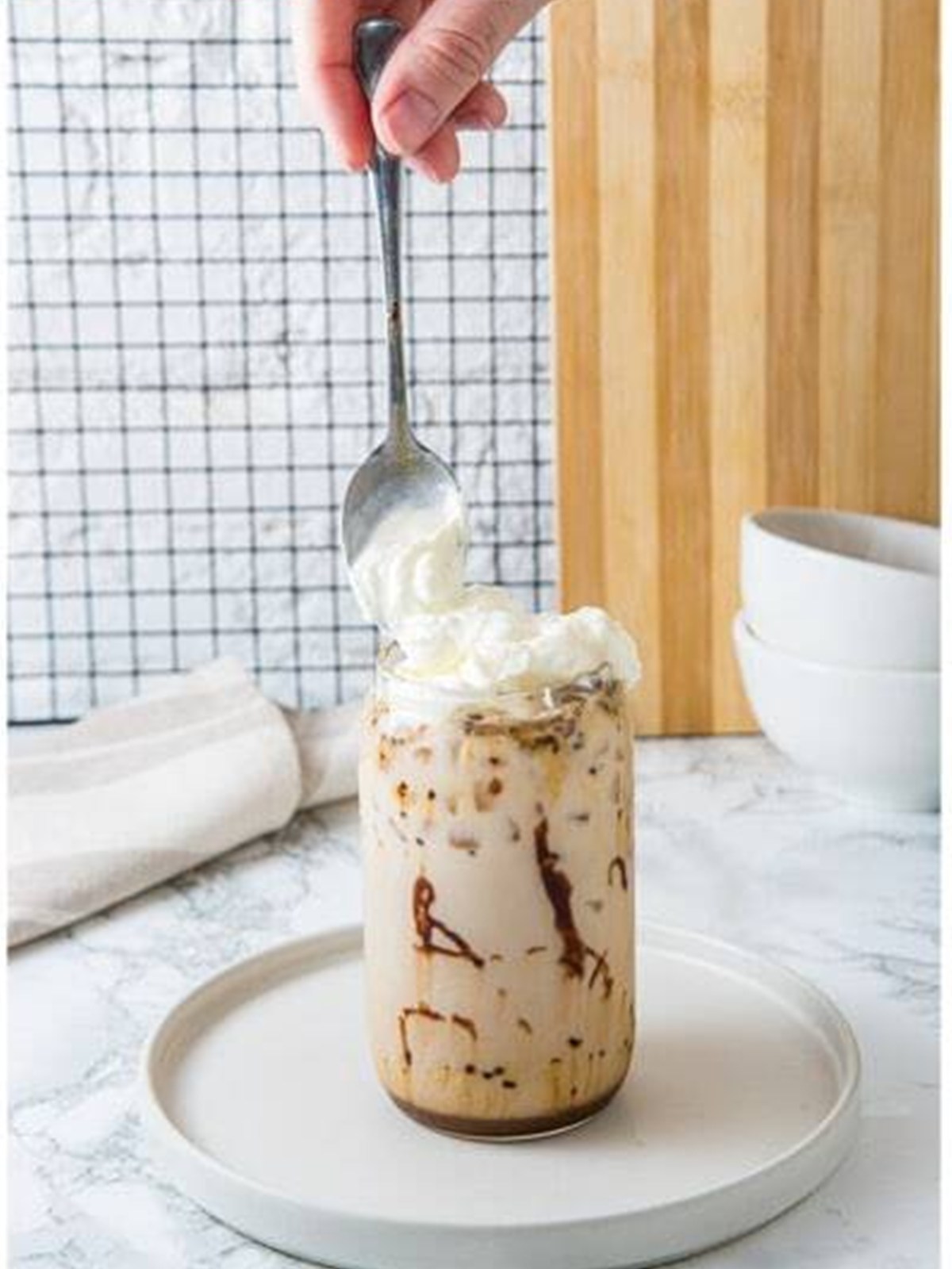 Topping the Iced Mocha with whipped cream.