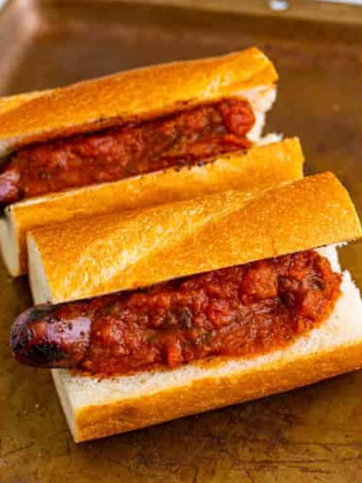 Warm marinara sauce spooned over grilled sausage in hoagie rolls.