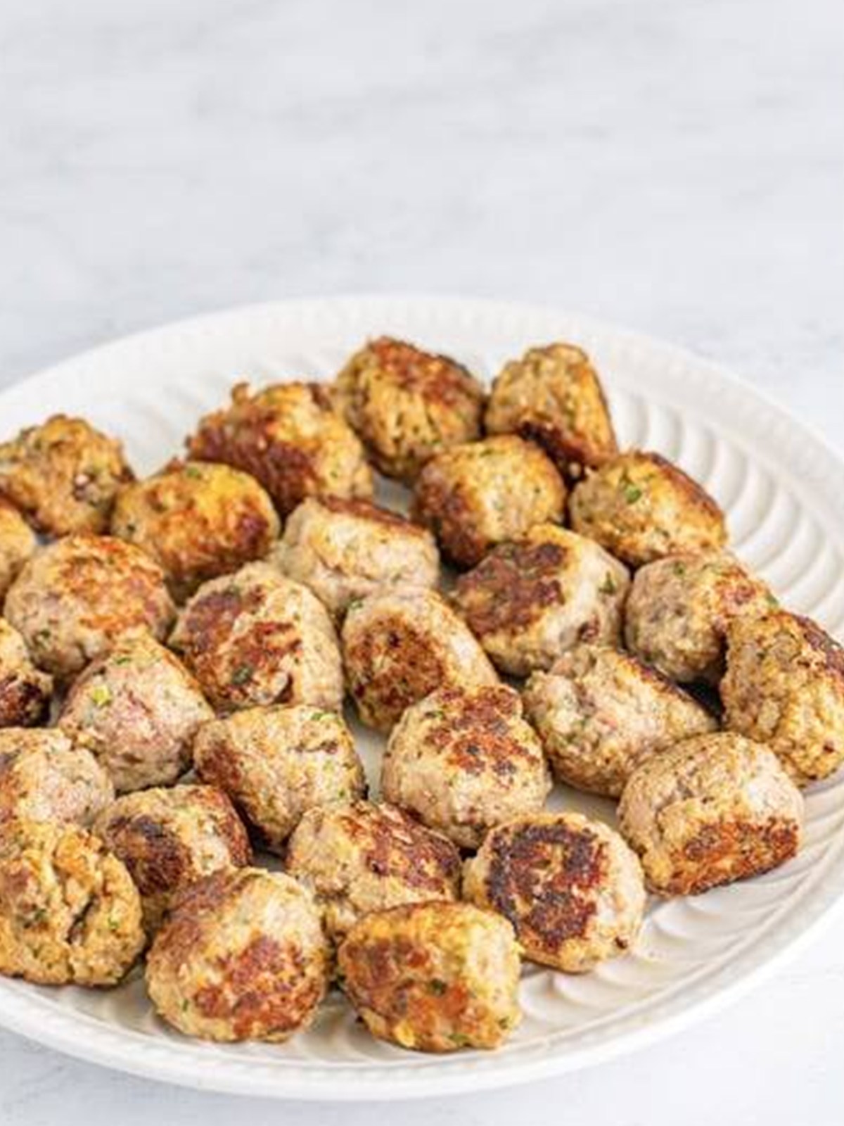 Browned mini meatballs on a plate for Italian Wedding Soup.