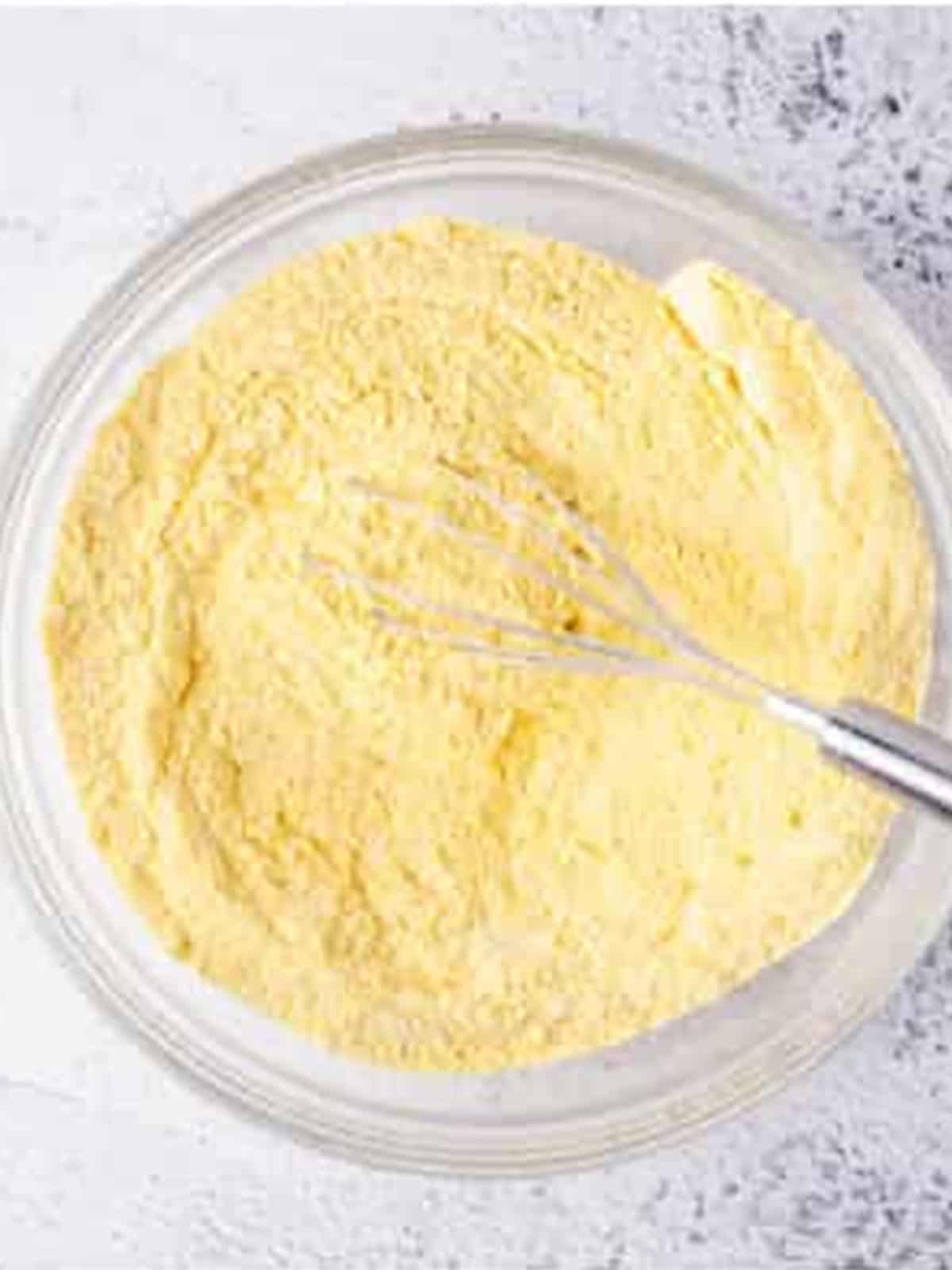 Cornmeal, flour, baking powder, and salt combined in a bowl for jalapeno cornbread.