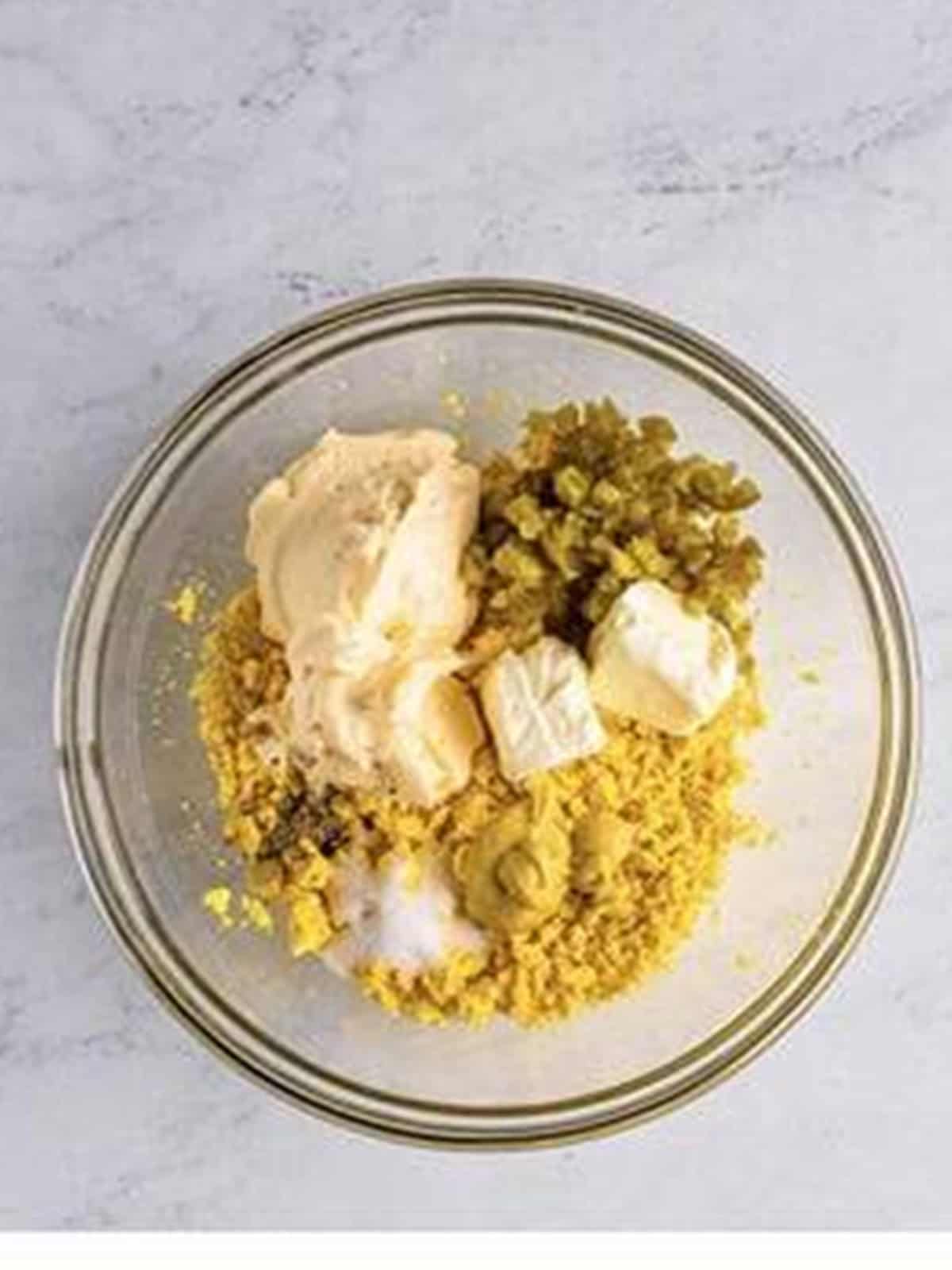Mayonnaise, cream cheese, pickled jalapenos, and dijon added to mashed egg yolks.