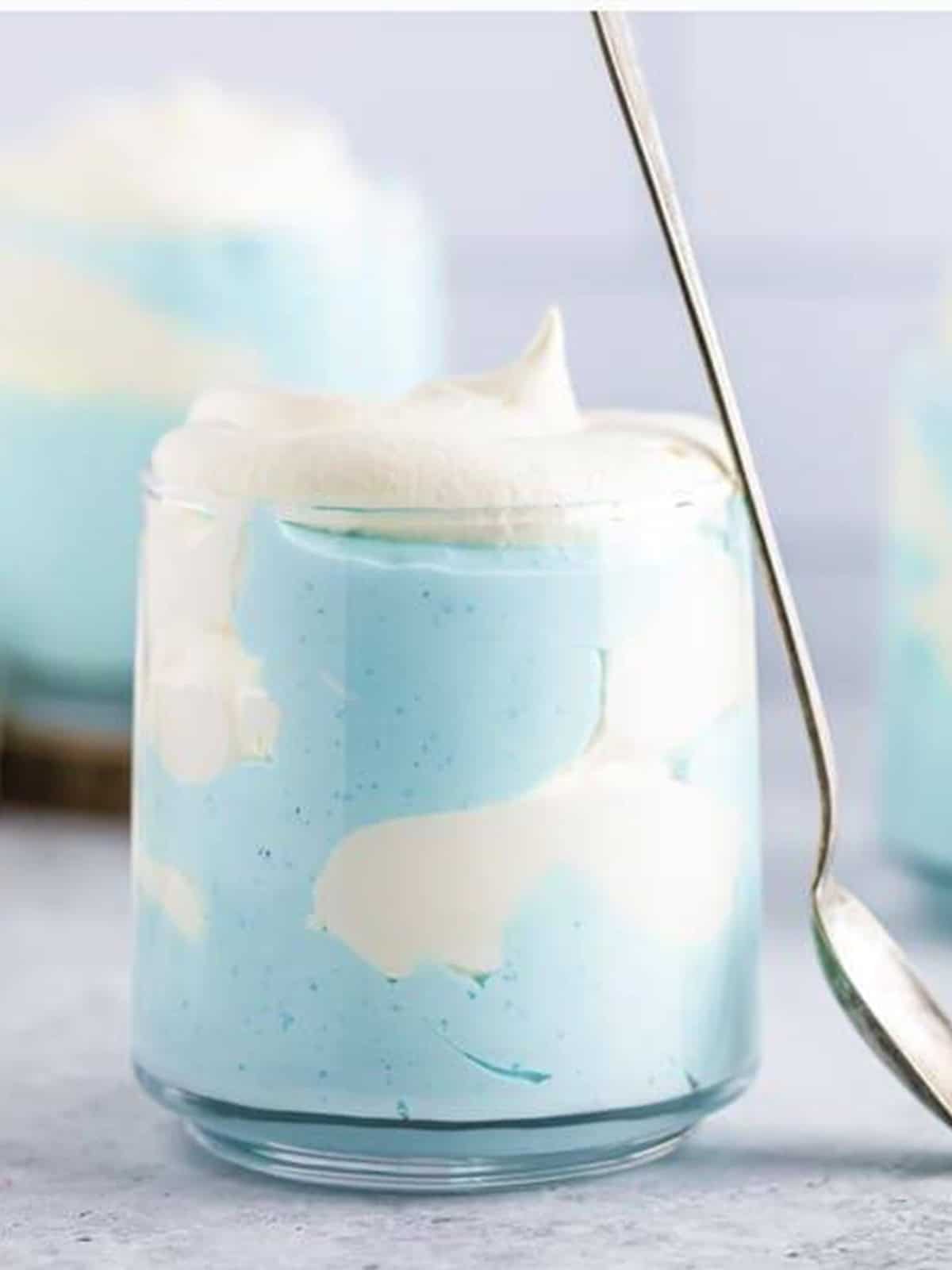 Finished layered jello cloud mousse in glasses with swirls of blue and white whipped topping.